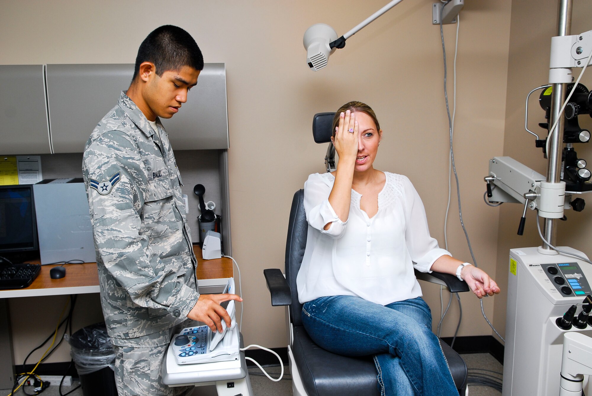 Airman 1st Class Lloydon Adler Balili, 56th Aerospace Medicine Squadron optometry technician, performs a contact lens vision check Tuesday on Becky Lauersdorf, 56th Civil Engineer Squadron administrative assistant, at the Luke Air Force Base Optometry Clinic. (U.S. Air Force photo/Senior Airman David Owsianka)