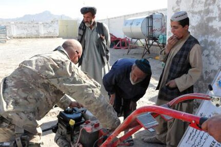 Mississippi National Guard member Staff Sgt. Dean Fennell shows Afghan farmers how to maintain a rotor-tiller at a demonstration farm in Shahr-e Safa, Afghanistan, Nov. 13, 2012.