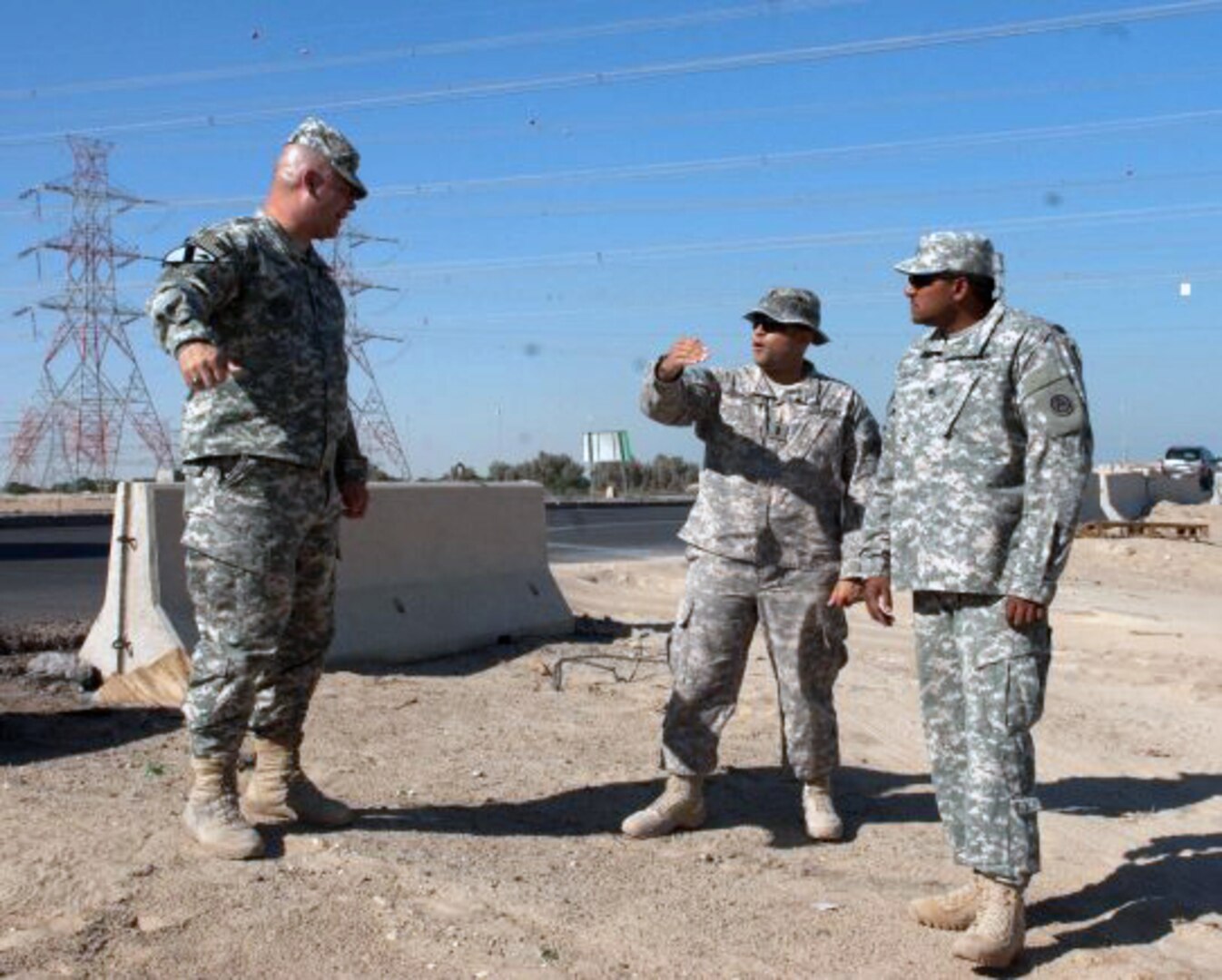 Master Sgt. Steve Kirby, force protection NCO for ASG Kuwait, left, 1st Lt. Teofilo Espinal, Base Defense Liaison Team (BDLT) officer-in-charge, center, and Staff Sgt. Miguel Santiago plan the placement of concrete barriers just outside the camp here in October.