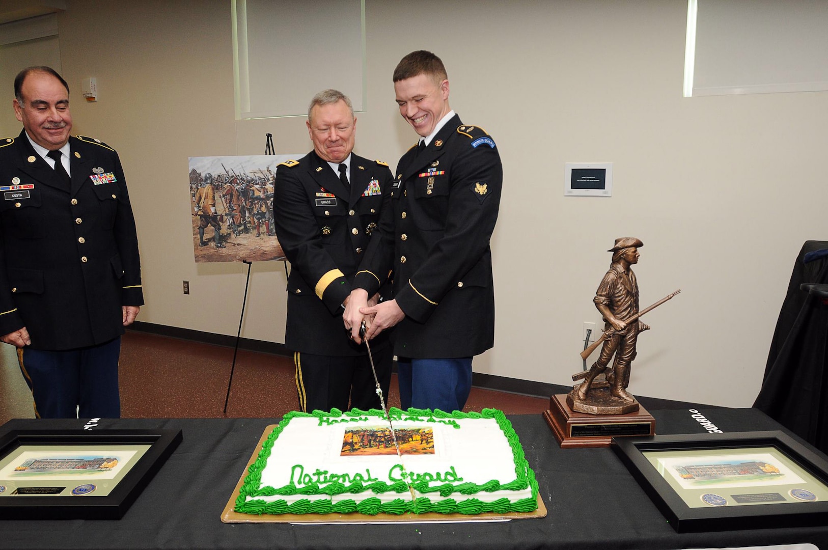 Gen. Frank Grass and Spc. Brendan Canary of the Massachusetts Army National Guard cut a cake celebrating the founding of the National Guard, Dec. 13, 2012. Command Sgt. Maj. David Costa looks on during the ceremony.