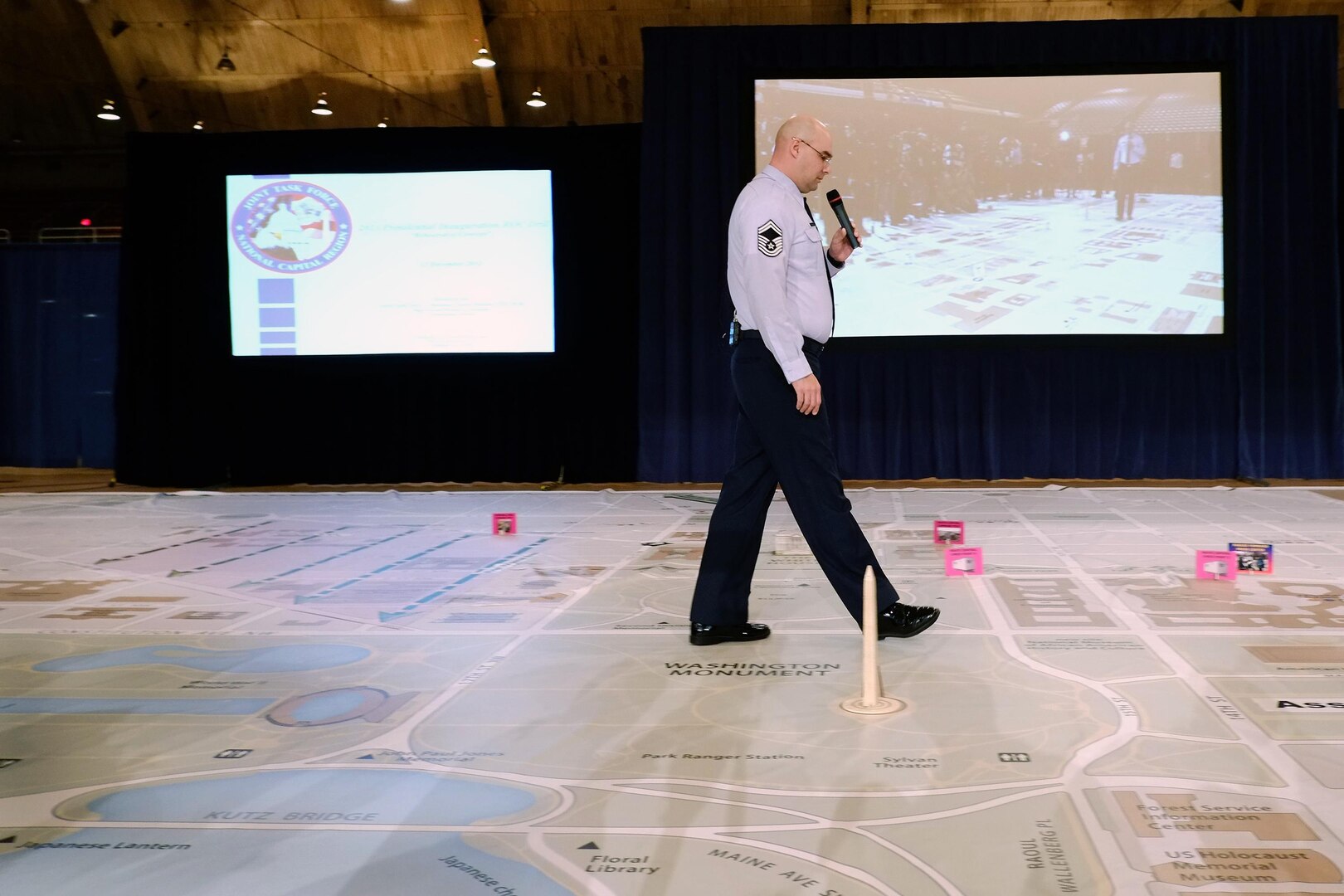 Senior Master Sgt. Scott Hinds, of the District of Columbia Air National Guard, walks along a large-scale map while giving a briefing on the 57th Presidential Inauguration on Dec. 12, 2012.