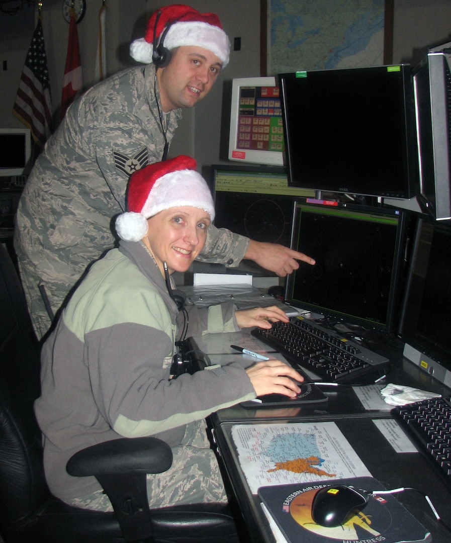 New York Air National Guard Airmen Staff Sgt. Jesse Bucenec, standing,and Sr. Airman Marie Coar, go through a Santa-tracking practice run on Dec. 19, 2012, at Eastern Air Defense Sector Headquarters.