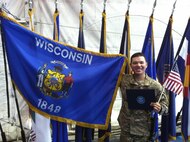 Sgt. Luis Cortes-Avila holds both the Wisconsin and U.S. flags in Bagram, Afghanistan on Nov. 2, 2012, after taking his oath of citizenship.