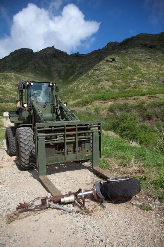 A piece of landing gear from a World War II-era patrol bomber aircraft is removed from Kaneohe Bay Range Training Facility aboard Marine Corps Base Hawaii, Aug. 20, 2013. Range and Training Area Management joined Coral Rasmussen, a base archeologist/cultural resource manager, to work with aviation archeologist David Trojan of the Travis Heritage Center to complete the collection and cataloguing the remainder of World War II-era aircraft surface artifacts located at K-Bay Range. Because of this, Marines have more flexibility to train in different areas of the Ulupau crater without hazards. One area that was cleared of material is now being used as a point-man course for infantry Marines, enhancing the utility of the range. (U.S. Marine Corps photo by Cpl. Matthew Callahan)
