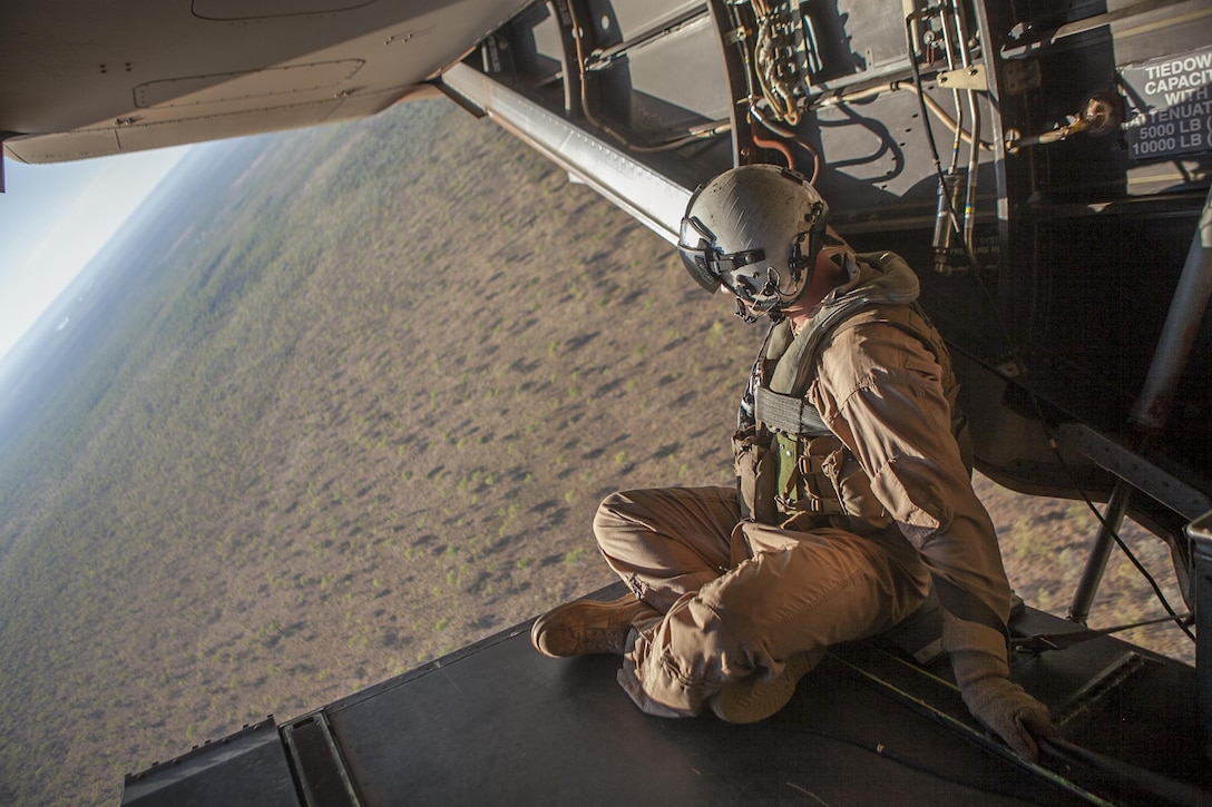 Sergeant Aaron Longberry, a 25-year-old crew chief with Marine Medium Tiltrotor Squadron 265 (Reinforced), 31st Marine Expeditionary Unit, and a native of Columbus, Ohio, sits on the ramp of an MV-22 Osprey while circling the training area during Exercise Koolendong 13 here, Aug. 30. The 31st MEU is moving a battalion-sized force more than 300 miles inland to conduct a live-fire training exercise. The exercise reinforces why the 31st MEU is the force of choice for the Asia-Pacific region. Also participating in the exercise is the Marine Rotational Force – Darwin and soldiers of the 5th Royal Australian Army. The 31st MEU, supported by the USS Bonhomme Richard Amphibious Ready Group, brings what it needs to sustain itself to accomplish the mission or to pave the way for follow-on forces. The size and composition of the 31st MEU makes it well suited for amphibious operations, which includes raids, assaults, evacuations and humanitarian assistance operations. 