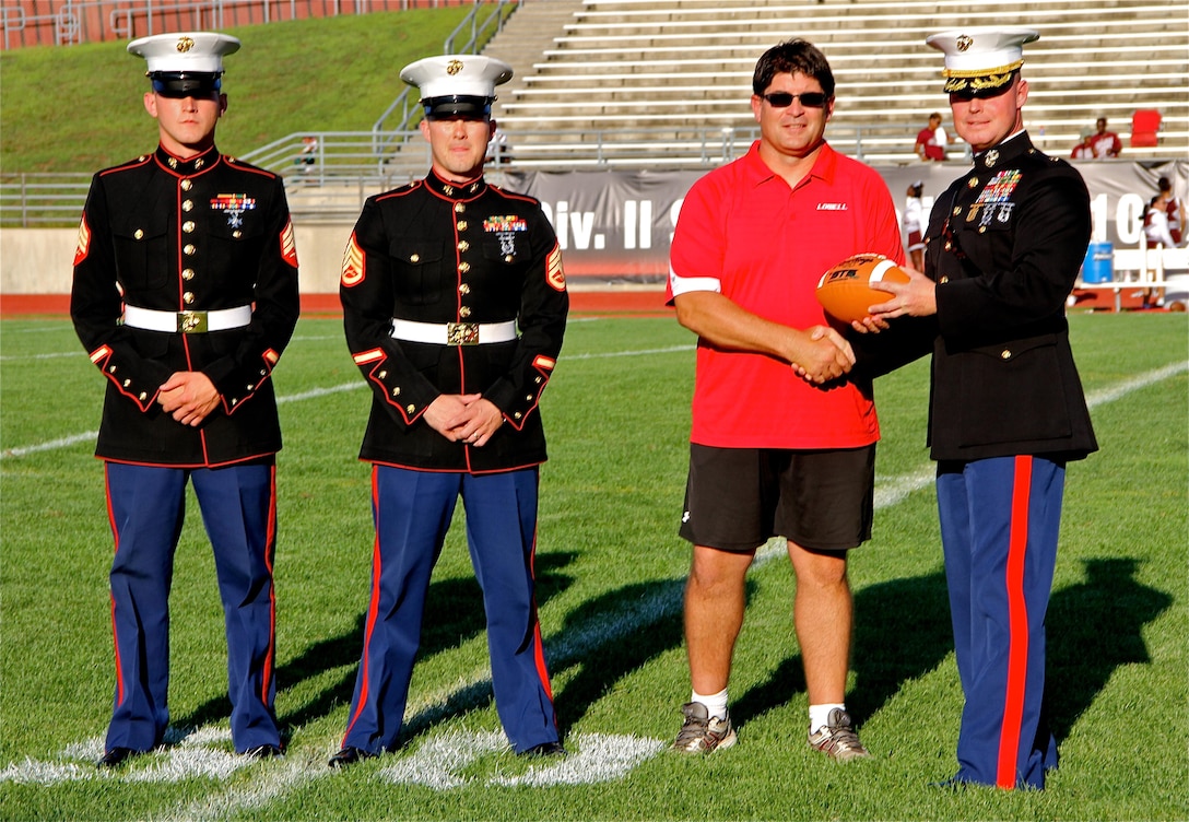 Lowell Red Arrow Head Coach Noel Dean is recognized by Marines of Recruiting Station Lansing as a 2013 Semper Fi Coach August, 29. Dean was originally presented the Semper Fi Coach award in February during the off season but the Marines and Lowell High School wanted to recognize him a second time in front of his home crowd in Lowell, Mich. Dean and the Lowell Community have raised over $800,000 since 2008 for breast cancer research through his "Pink Arrow Project". 