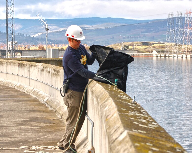Corps of Engineers and Wash. Department of Fish and Wildlife employes dewater The Dalles Dam fish ladder. Fish remaining in the ladder are collected and returned to the Columbia River.