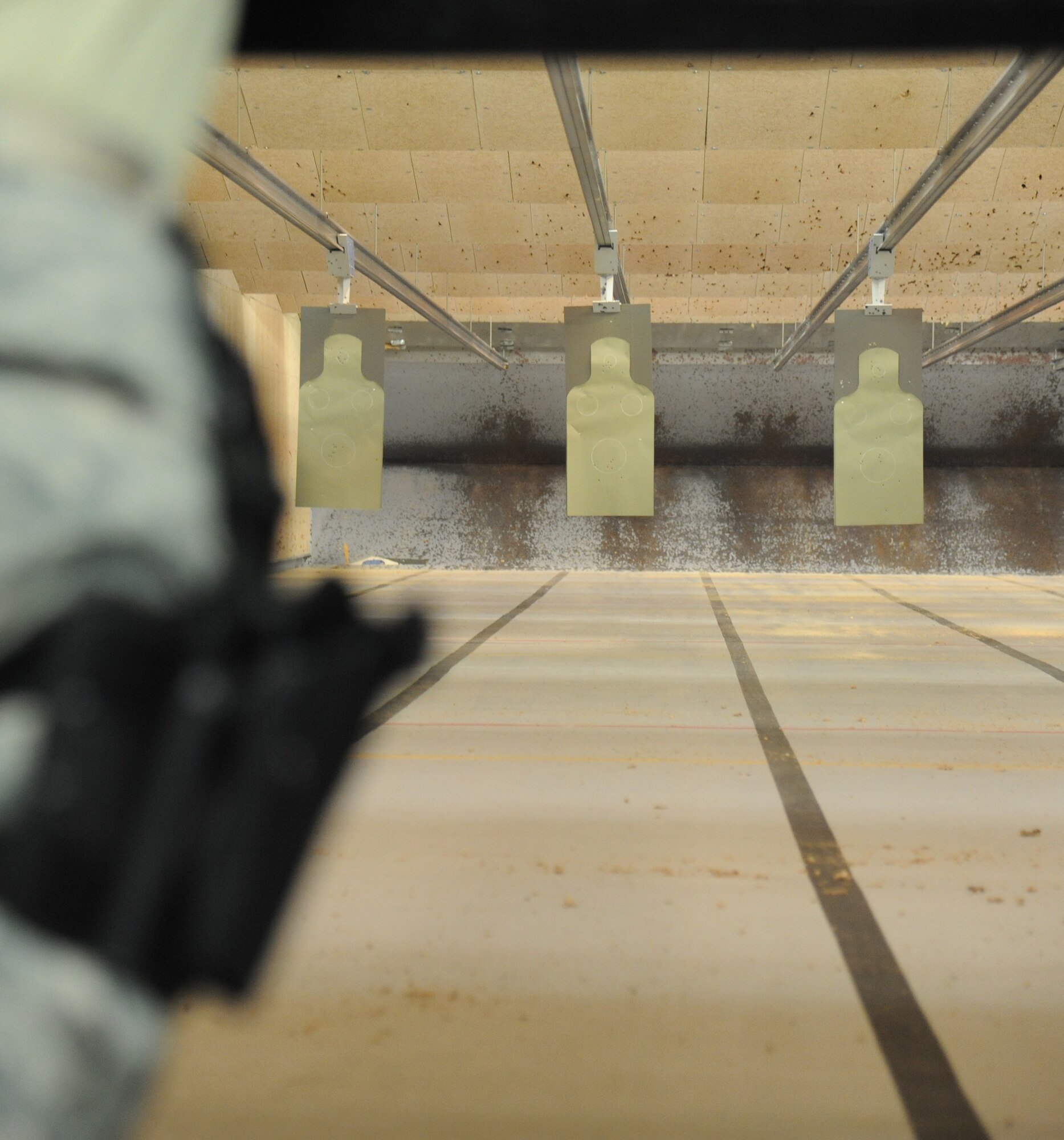 A member of the 81st Security Forces Squadron engages targets during the second annual Air Force Office of Special Investigations and the 81st Security Forces Squadron’s pistol shoot-off competition Aug. 30, 2013, at the indoor firing range, Keesler Air Force Base, Miss.  Nine five-man teams from local law enforcement agencies competed in the event.  (U.S. Air Force photo by Kemberly Groue)