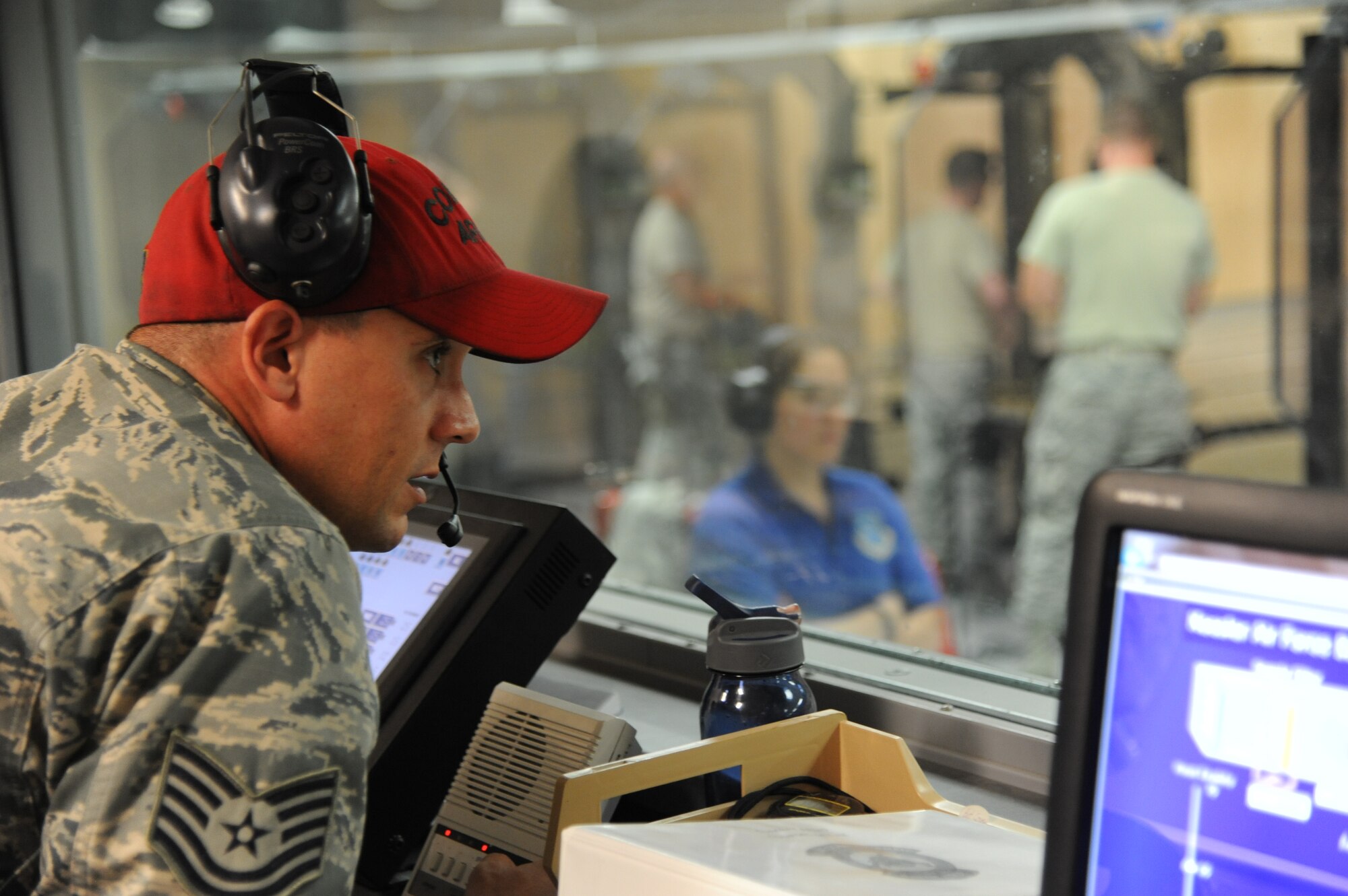 Tech. Sgt. Jonathan Johnson, 81st Security Forces Squadron combat arms, announces the course of fire and range safety rules from the indoor firing range tower during the second annual Air Force Office of Special Investigations and the 81st Security Forces Squadron’s pistol shoot-off competition Aug. 30, 2013, at the indoor firing range, Keesler Air Force Base, Miss.  Nine five-man teams from local law enforcement agencies competed in the event.  (U.S. Air Force photo by Kemberly Groue)