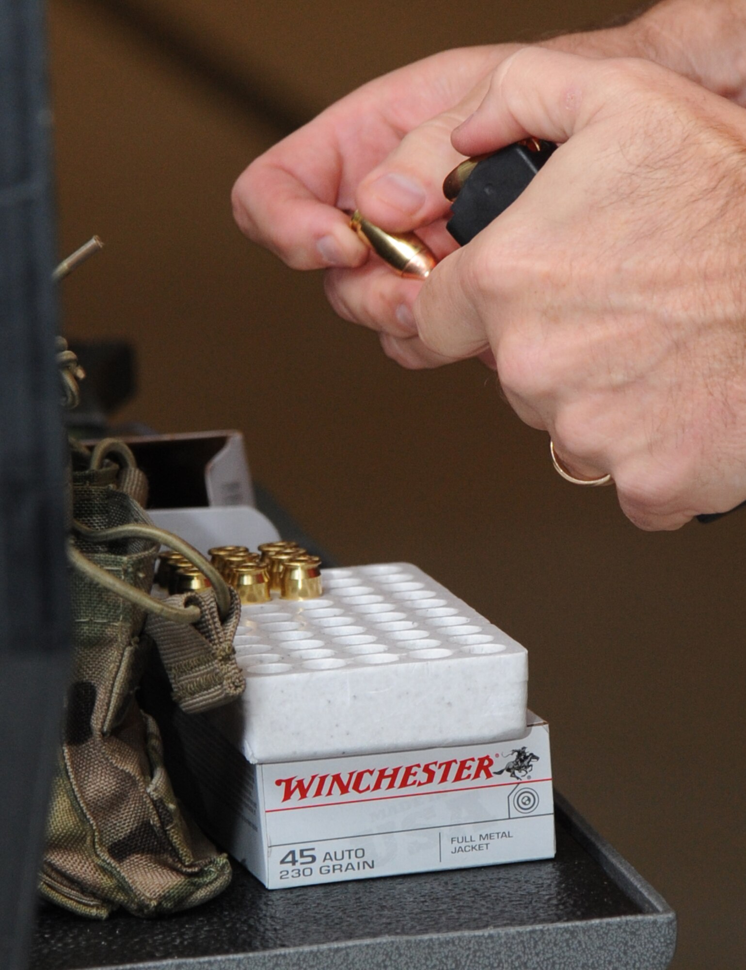 Sergeant Klint Krieger, Biloxi Police Department, loads a magazine with ammunition during the second annual Air Force Office of Special Investigations and the 81st Security Forces Squadron’s pistol shoot-off competition Aug. 30, 2013, at the indoor firing range, Keesler Air Force Base, Miss.  Nine five-man teams from local law enforcement agencies competed in the event.  (U.S. Air Force photo by Kemberly Groue)