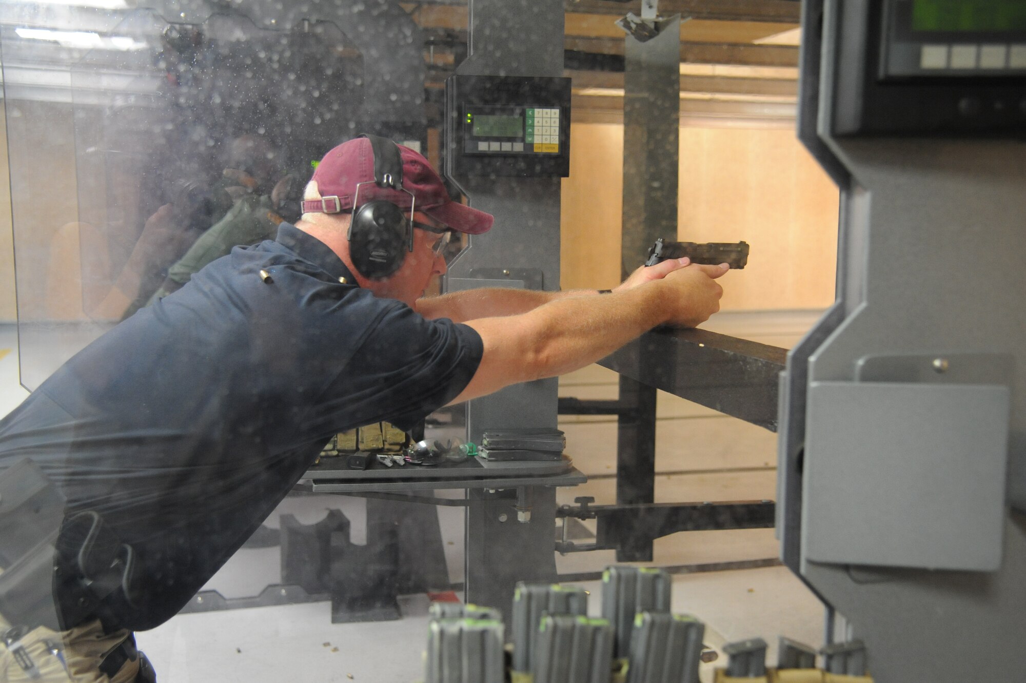 Special Agent Steve Lindgren, Homeland Security, fires rounds at a target during the second annual Air Force Office of Special Investigations and the 81st Security Forces Squadron’s pistol shoot-off competition Aug. 30, 2013, at the indoor firing range, Keesler Air Force Base, Miss.  Nine five-man teams from local law enforcement agencies competed in the event.  (U.S. Air Force photo by Kemberly Groue)