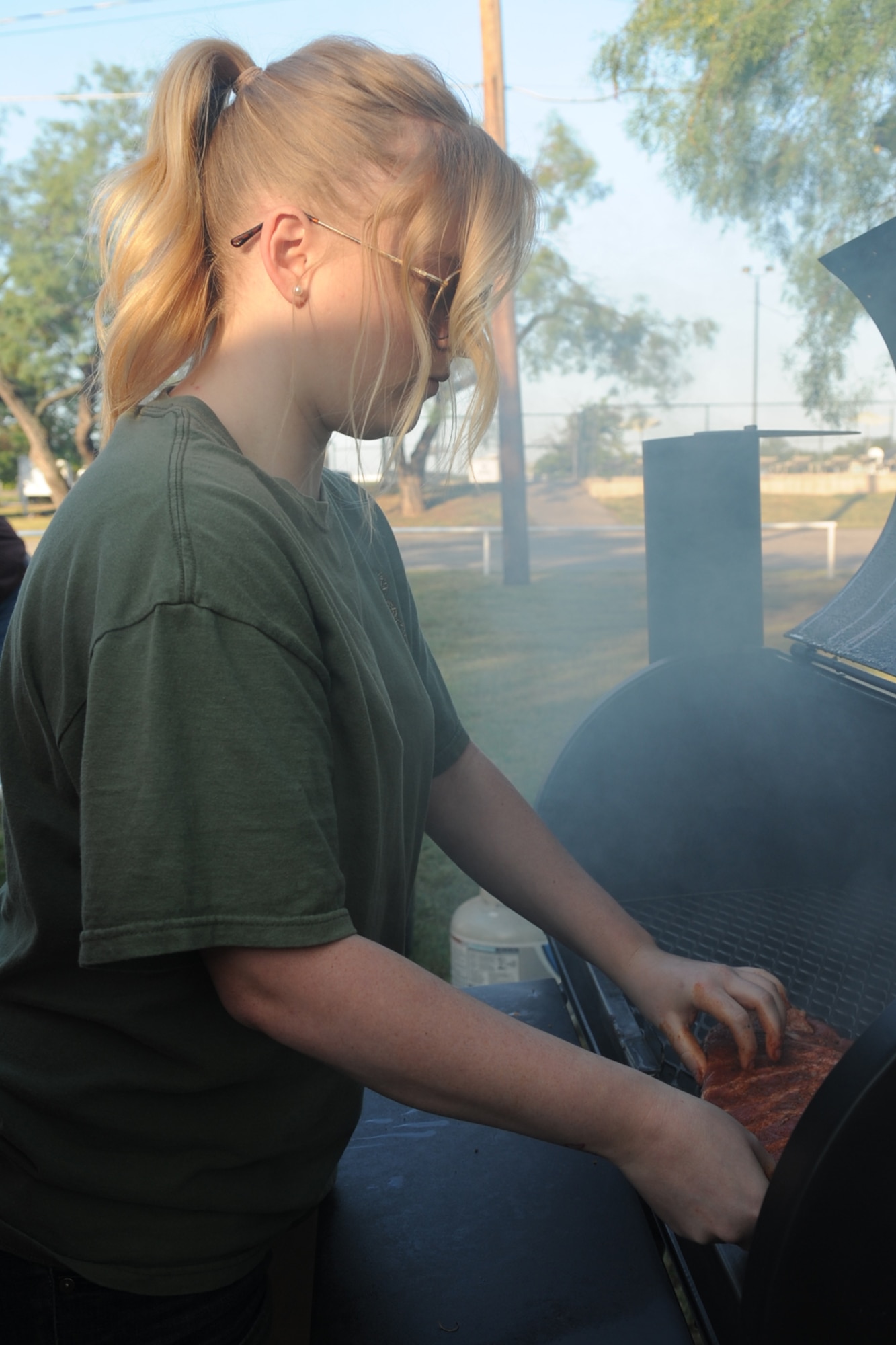 SAN ANGELO, Texas -- Airman 1st Class Kaitlin LeVasseur, 17th Training Wing Command Post, adds ribs to the grill during a cooking class at the Goodfellow Recreation Camp Aug. 24. The 17th Force Support Squadron hosted the class to give Airman and base members a chance to get out of their rooms and cook food. (U.S. Air Force photo/Staff Sgt. Laura R. McFarlane)