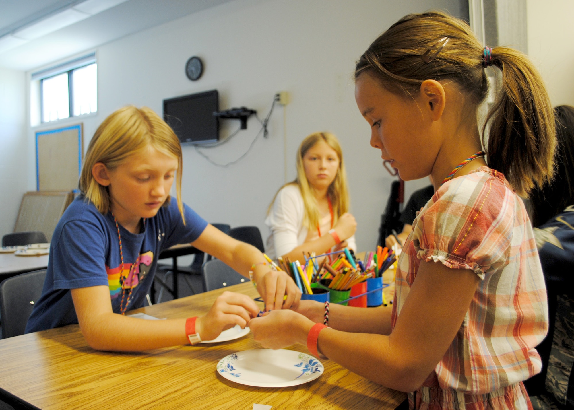 Breanna Feldhausen, 10 (left), and Cierra Leal, 10, help each other make crafts during Vacation Bible School on Aug. 20.  (U.S. Air Force photo/Senior Airman Cortney Paxton)