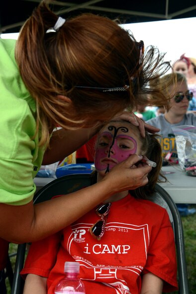 Amy Adams, a 341st Force Support Squadron Child Development Center preschool caregiver, paints a butterfly on a child’s face during the annual Malmstrom Air Force Base picnic Aug. 23 at Sun Plaza Park. Children could enjoy games, bounce castles, face painting, snow cones and cotton candy during the event. (U.S. Air Force photo/Staff Sgt. R.J. Biermann) 