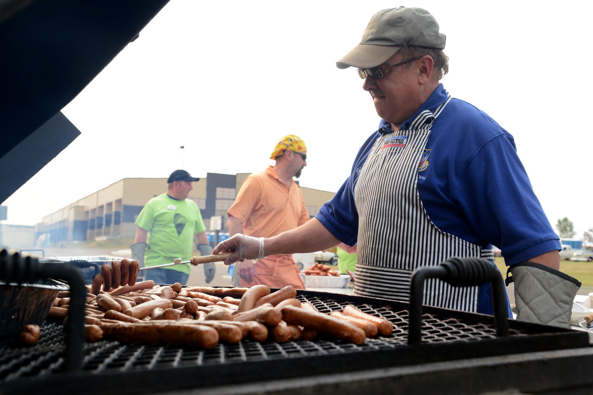 Gordon Johnson, a Great Falls, Mont., Chamber of Commerce Military Affairs Committee member, flips hot dogs at the annual Malmstrom Air Force Base picnic at Sun Plaza Park on Aug. 23. Volunteers grilled up more than 3,000 hamburgers and hot dogs for the event. (U.S. Air Force photo/Staff Sgt. R.J. Biermann)