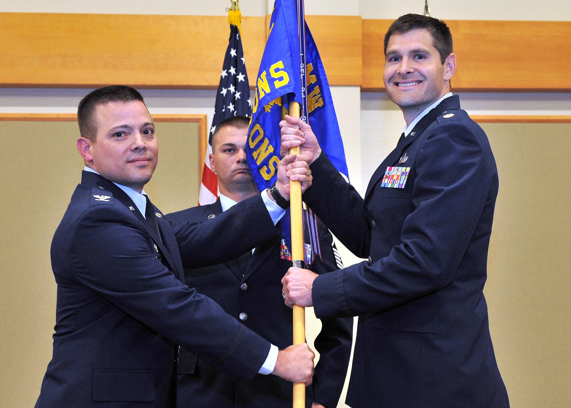 Maj. John Spear, right, accepts command of the 341st Contracting Squadron from Col. Monte Harner, 341st Mission Support Group commander, Aug. 26 at the Grizzly Bend.  Master Sgt. Robert Price, 341st CONS acting first sergeant, looks on.  (U.S. Air Force photo/ John Turner)