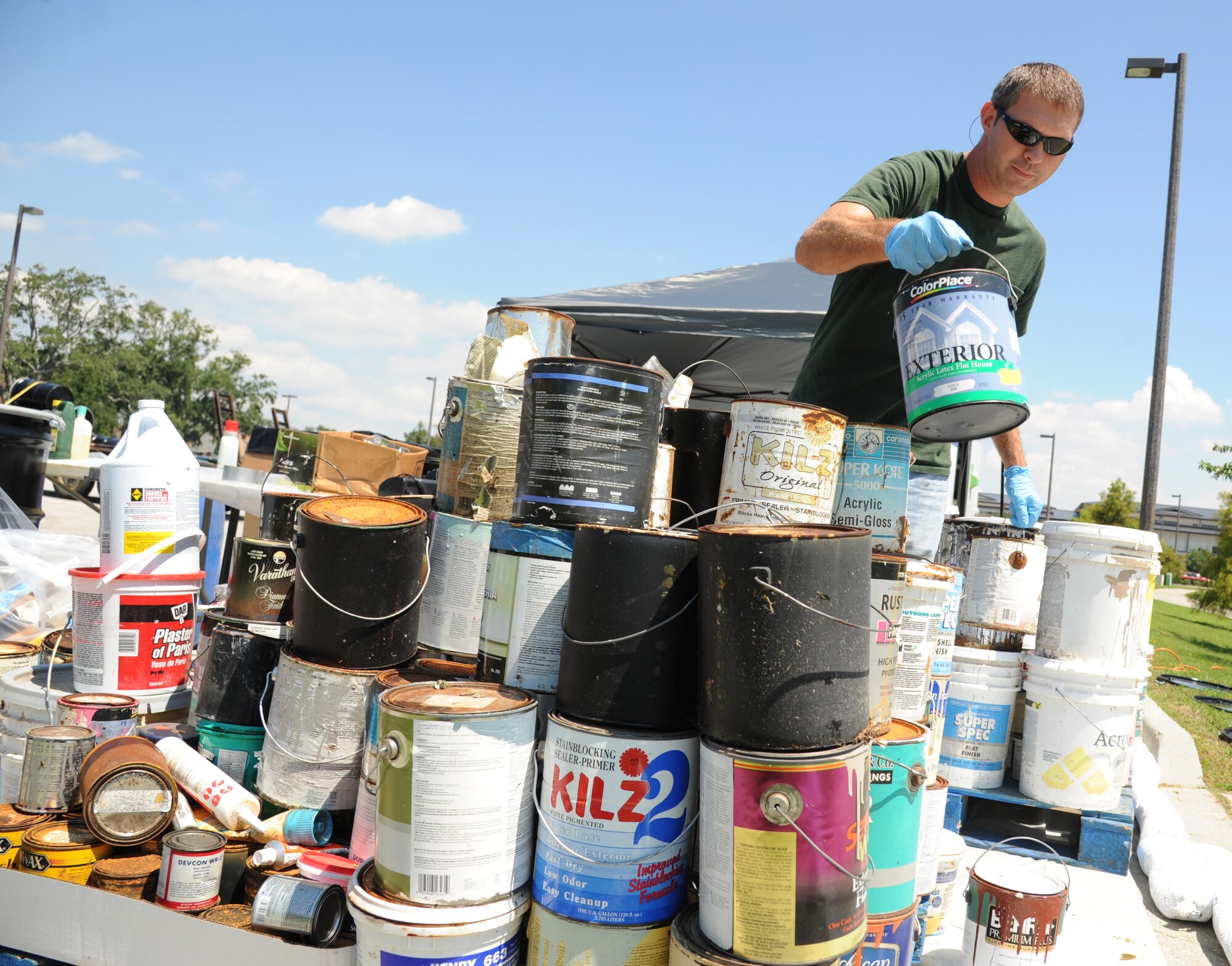 Jacob Ferguson, Complete Environmental and Remediation Co., LLC technician, sorts buckets of paints from other hazardous chemicals during a hazardous household waste collection event Aug. 29, 2013, at the Bay Breeze Event Center parking lot, Keesler Air Force Base, Miss.  The event was hosted by the base environmental office.  (U.S. Air Force photo by Kemberly Groue)