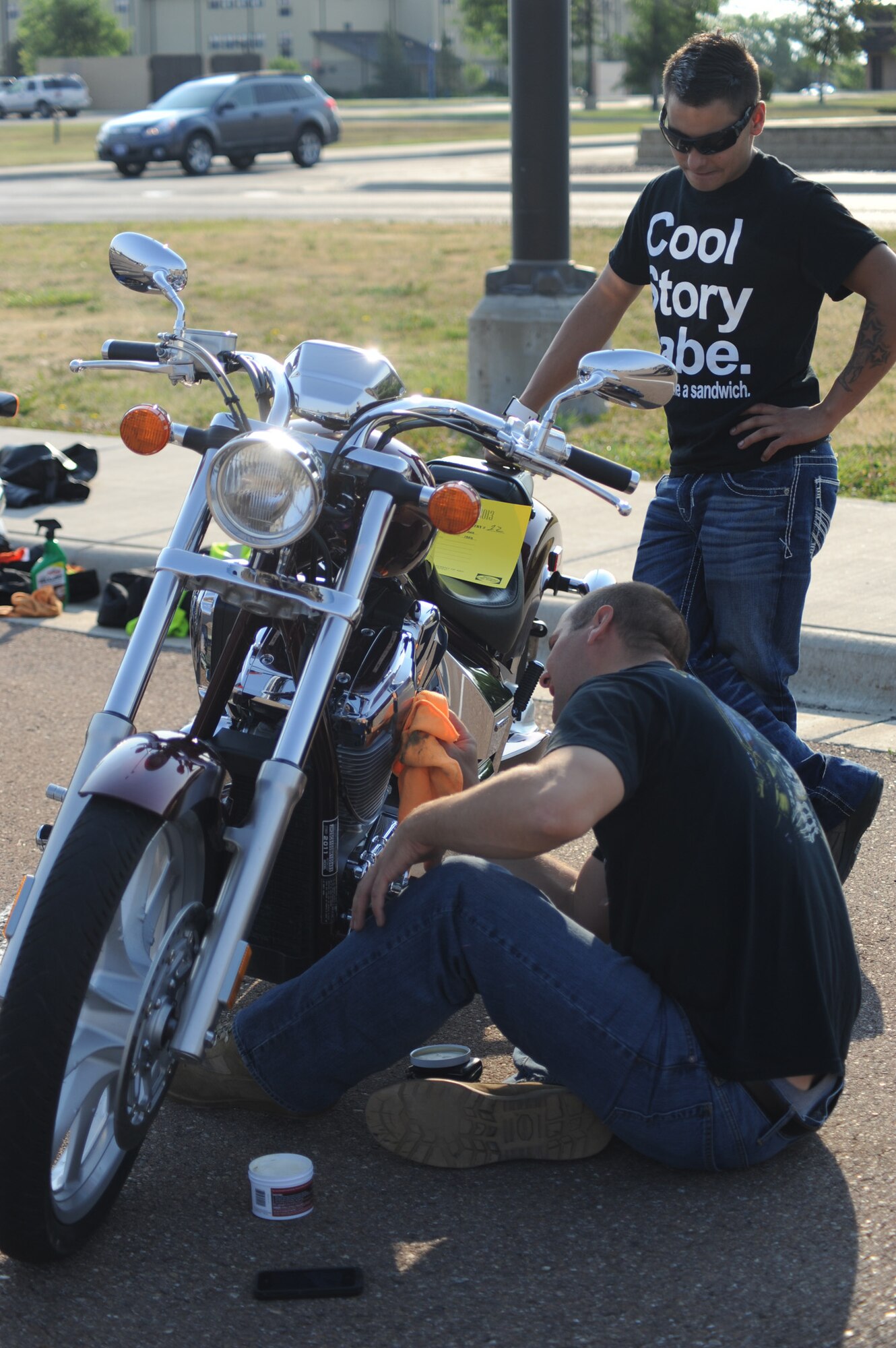 Staff Sgt. Josh Leopardi, 341st Maintenance Operations Squadron missile maintenance technician, cleans his bike before the start of the bike show as Staff Sgt. Phillip Smith, 341st MOS technician, watches nearby.  Along with the bike show, the Rolling Thunder motorcycle safety event featured vendors, food cooked by Malmstrom’s Top 3, a mentorship ride and a motorcycle that held three speed records in 1989.  (U.S. Air Force photo/Senior Airman Cortney Paxton)