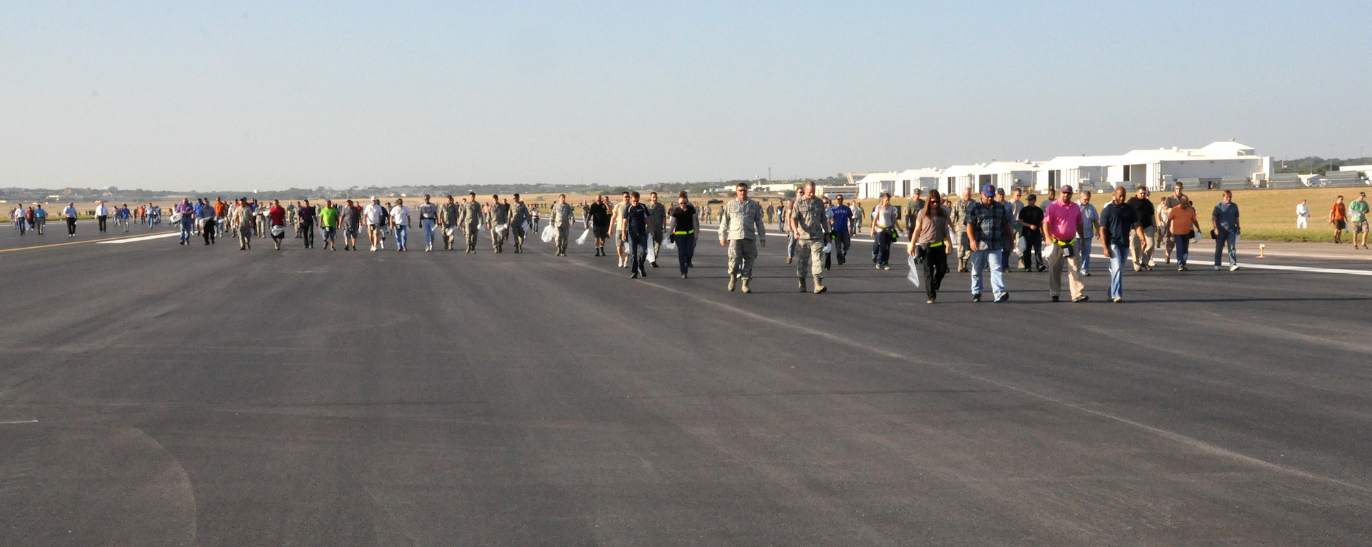 Lockheed Martin employees join in the Naval Air Station Fort Worth Joint Reserve Base Foreign Object Debris (FOD) walk August 29 prior to aircraft returning to the base. FOD creates safety hazards and can ultimately impact safe operations by damaging aircraft. All aircraft and support personnel are schedule to once again operate from the base by the end of August. (U.S. Air Force photo/Master Sgt. Julie Briden-Garcia)