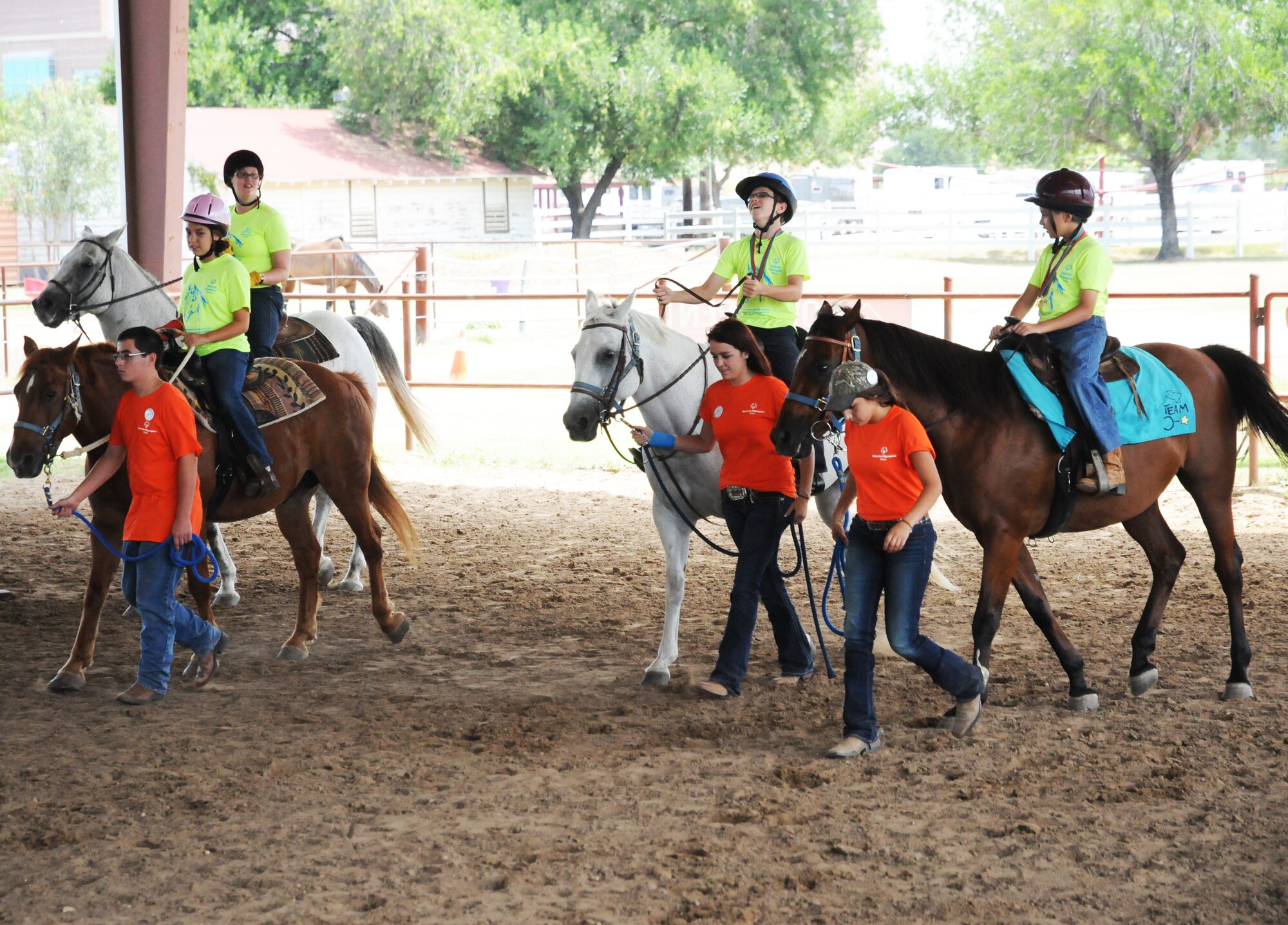 Exceptional Family Member Program athletes and volunteers make their way back to the starting line after a race during a Special Olympics equestrian competition Aug. 13 at the Joint Base San Antonio-Fort Sam Houston Equestrian Center. (U.S. Air Force photo by Airman 1st Class Alexandria Slade)