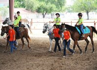 Exceptional Family Member Program athletes and volunteers make their way back to the starting line after a race during a Special Olympics equestrian competition Aug. 13 at the Joint Base San Antonio-Fort Sam Houston Equestrian Center. (U.S. Air Force photo by Airman 1st Class Alexandria Slade)