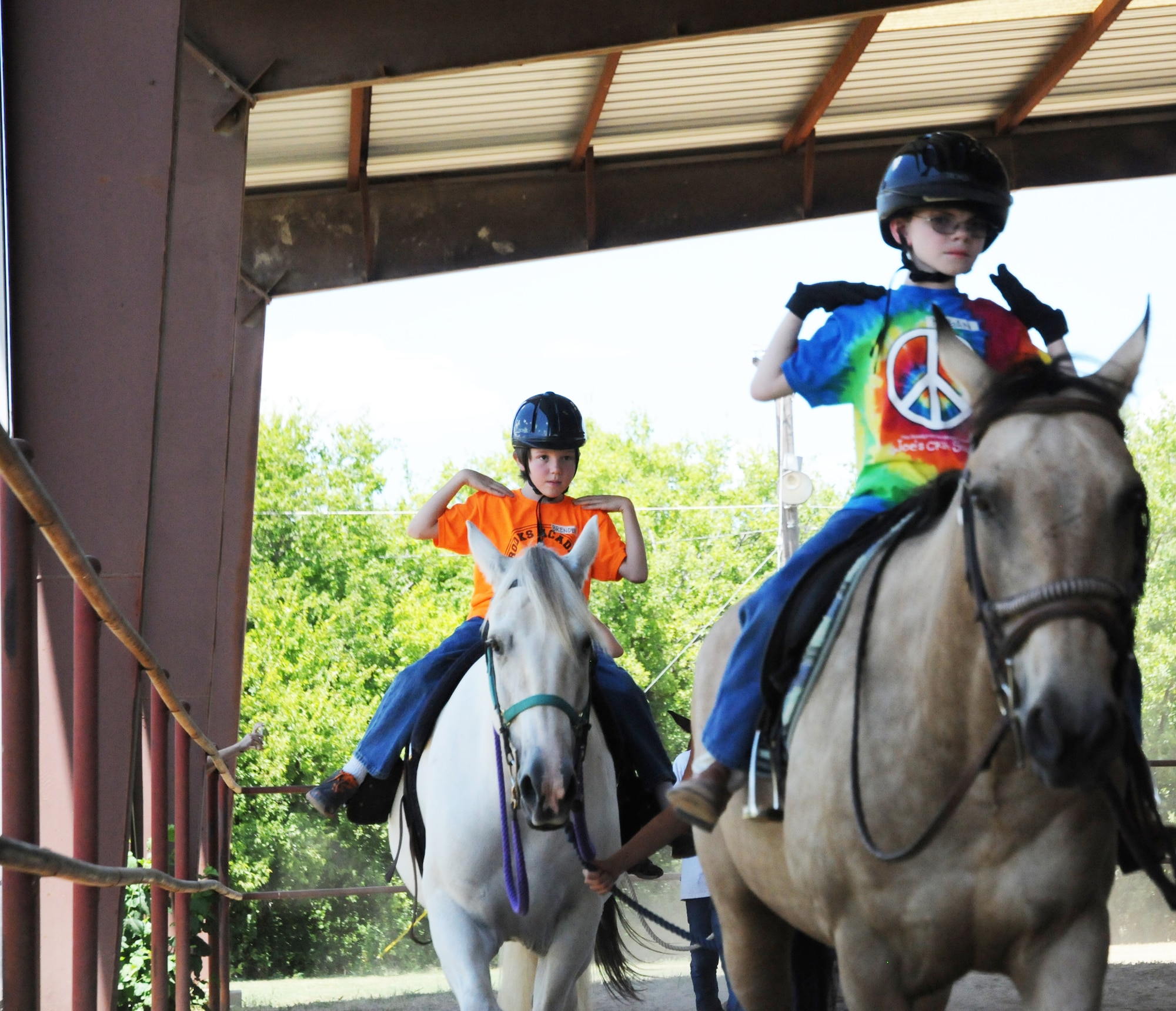 Brenden Hoopes (left) and Kegan Neufeld (right), Exceptional Family Member Program athletes, participate in an exercise using listening skills and balance during a Special Olympics equestrian camp Aug. 13 at the Joint Base San Antonio-Fort Sam Houston Equestrian Center. (U.S. Air Force photo by Airman 1st Class Alexandria Slade)