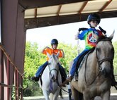 Brenden Hoopes (left) and Kegan Neufeld (right), Exceptional Family Member Program athletes, participate in an exercise using listening skills and balance during a Special Olympics equestrian camp Aug. 13 at the Joint Base San Antonio-Fort Sam Houston Equestrian Center. (U.S. Air Force photo by Airman 1st Class Alexandria Slade)