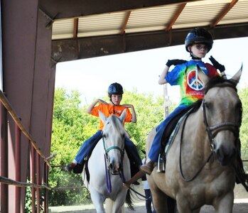 Brenden Hoopes (left) and Kegan Neufeld (right), Exceptional Family Member Program athletes, participate in an exercise using listening skills and balance during a Special Olympics equestrian camp Aug. 13 at the Joint Base San Antonio-Fort Sam Houston Equestrian Center. (U.S. Air Force photo by Airman 1st Class Alexandria Slade)