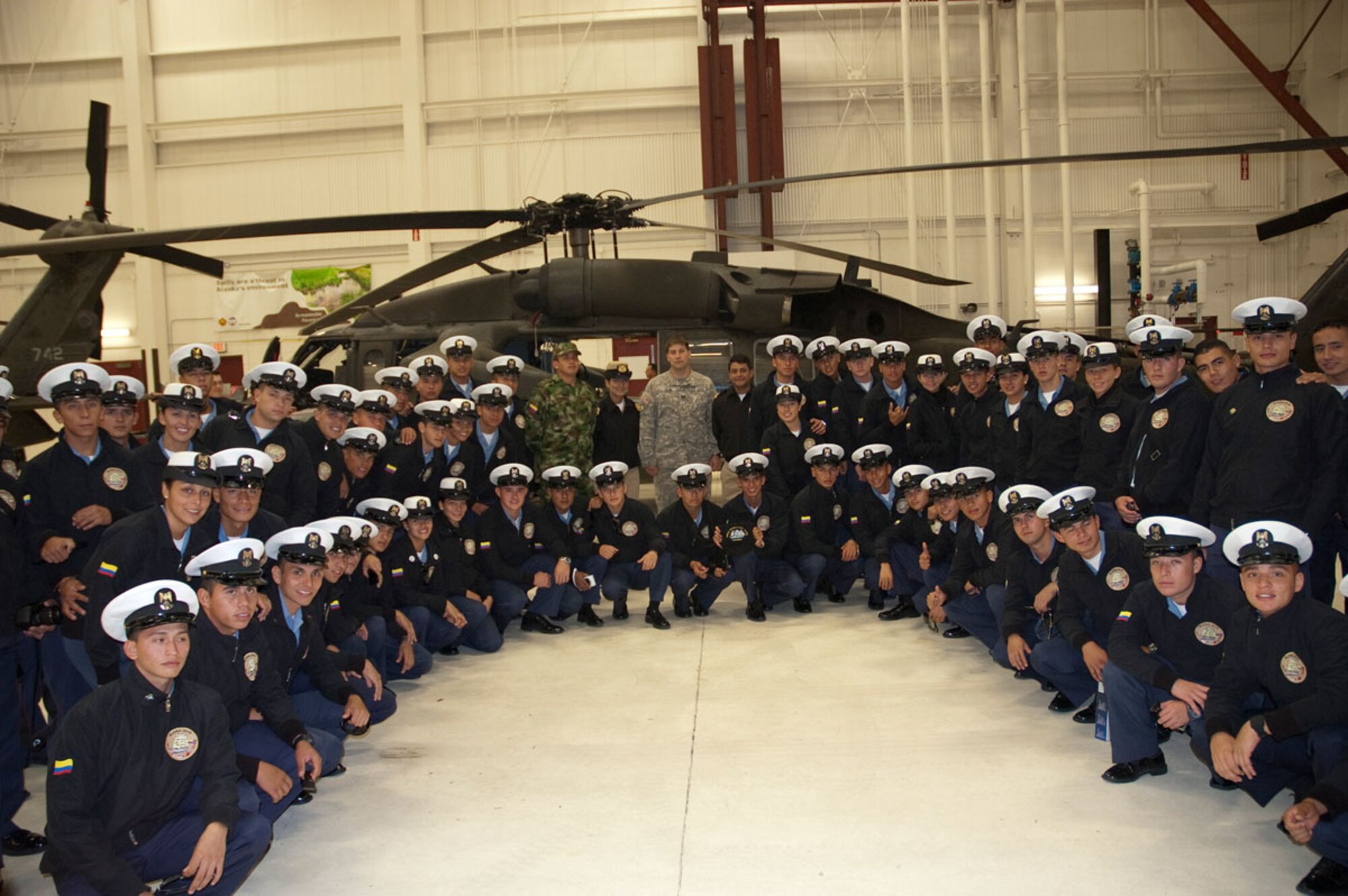 Colombian Naval Academy cadets and Colombian Navy personnel gather in front of Alaska Air National Guard UH-60 Black Hawk helicopters. (U.S. Air Force photo/2nd Lt Michael Harrington)