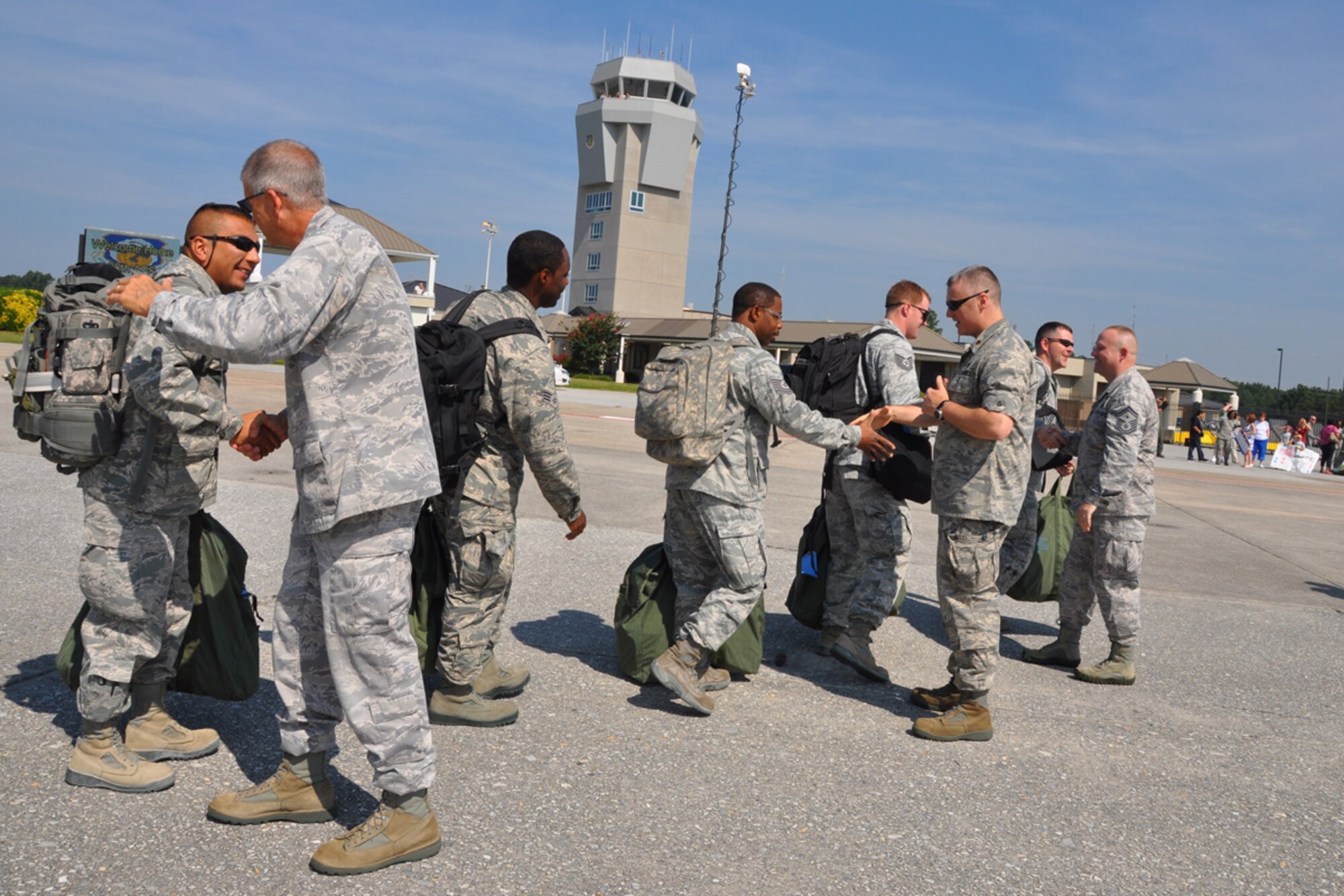 Col. Tim Tarchick, 94th Airlift Wing commander, Maj. Kelly Bronson, 80th Aerial Port Squadron commander and Senior Master Sgt. David Strickland, 80th APS first sergeant, welcome over 20 aerial porters home from a six-month deployment to Southwest Asia Aug. 27. The Airmen were greeted by family members and friends who they had not seen since February. (U.S. Air Force photo/James Branch)