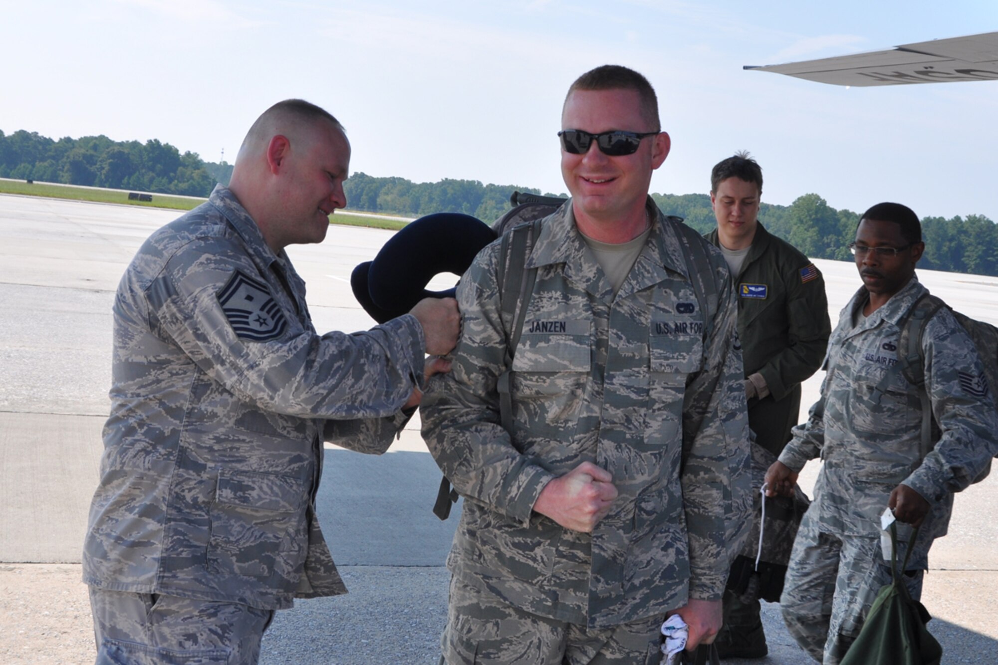 Senior Master Sgt. David Strickland, 80th Aerial Port Squadron first sergeant, congratulates recently promoted Staff Sgt. Cameron Janzen during his from a six-month deployment to Southwest Asia Aug. 27. The crew was greeted by family members and friends who they had not seen since February. (U.S. Air Force photo/James Branch)