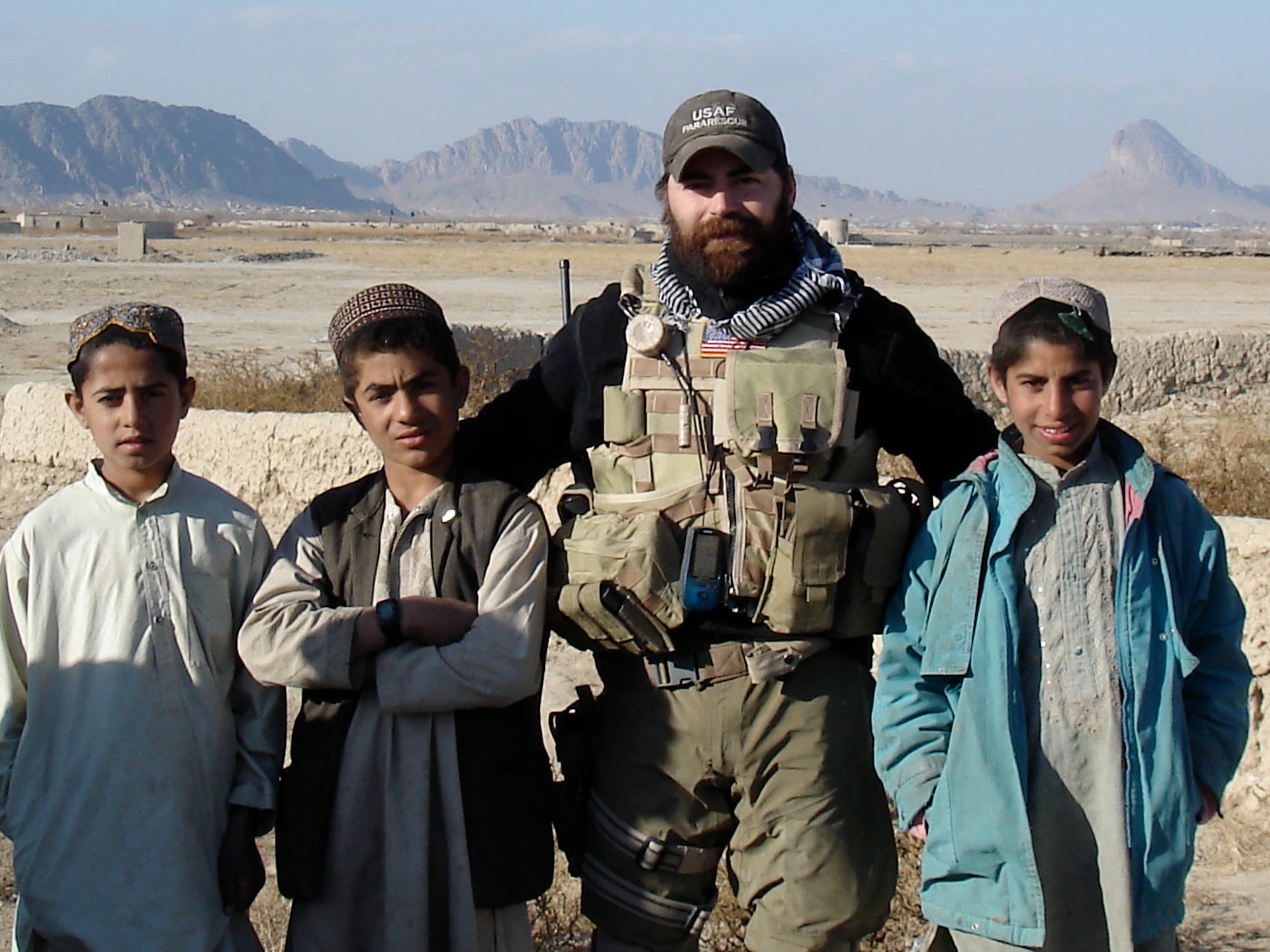 Hardy poses with Afghan children during an operation to deliver supplies and medical aid to an Afghan village threatened by Haqqani terrorists in 2009. (U.S. Air Force/Courtesy photo)