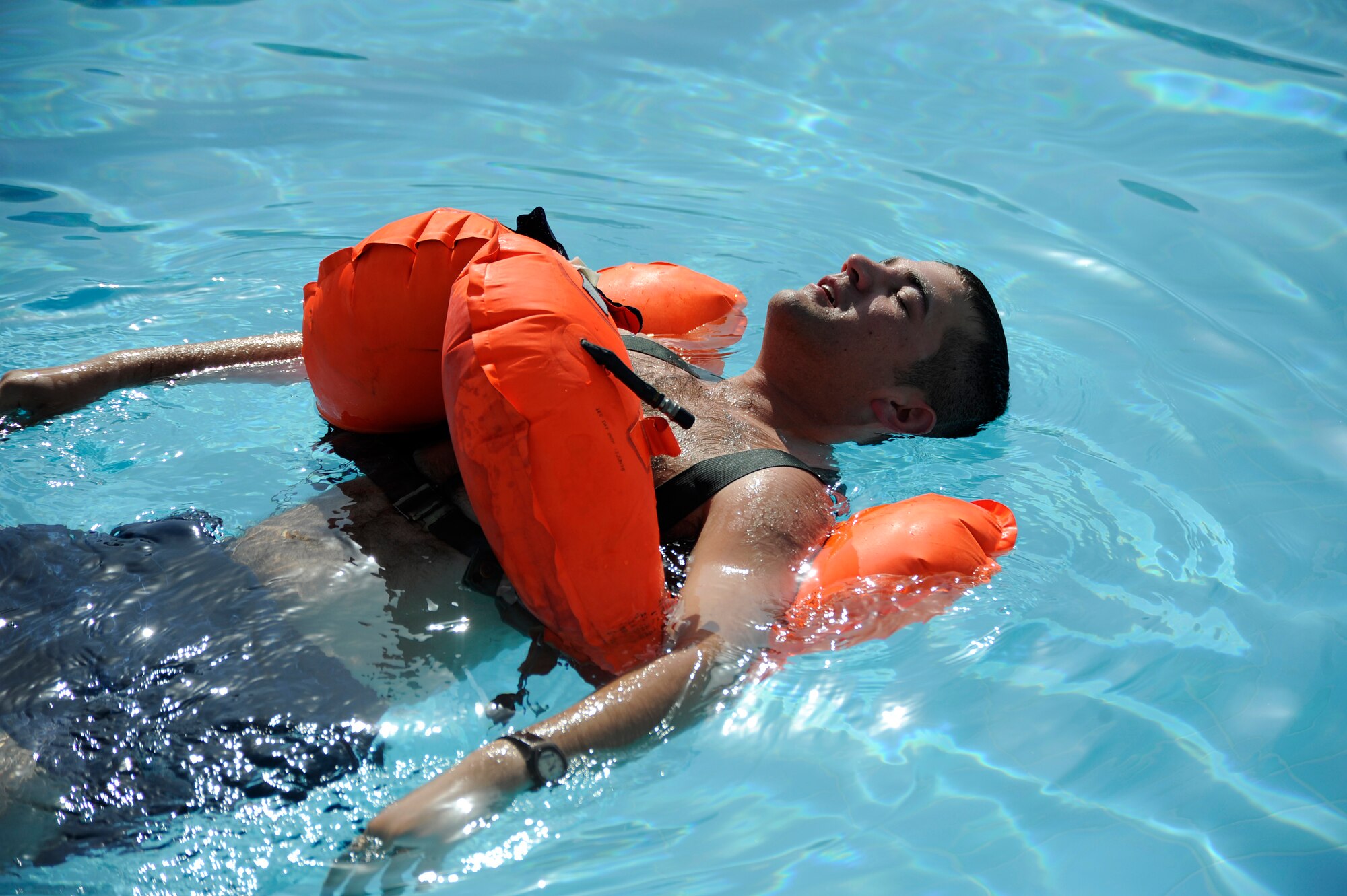 Senior Airman Anthony Serrels, 386th Expeditionary Civil Engineer Squadron, demonstrates proper use of a life vest here Aug. 29, 2013. Serrels is training host-nation aircrew on water survival techniques with different life support equipment. Here he is showing floating with a life vest to conserve energy. Serrels, a native of La Peer, Mich., is deployed out of the 110th Airlift Wing, Battle Creek, Mich., Air National Guard unit. (U.S. Air Force photo by Master Sgt. Christopher A. Campbell)