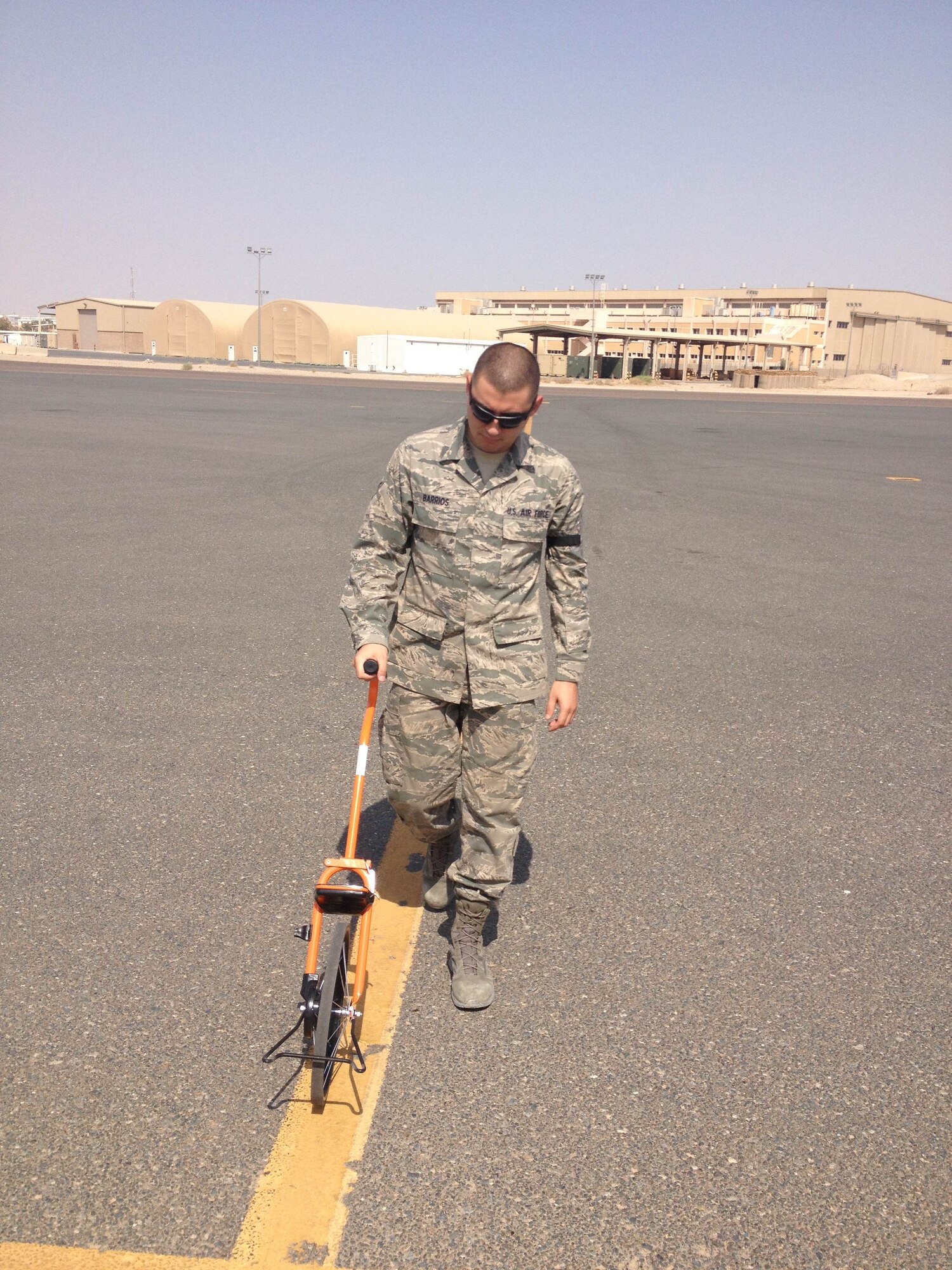 Senior Airman Luis Barrios measures airfield apron dimensions to ensure the proper criteria is met for the base's parking plan.  He is an airfield management shift lead at the 386th Expeditionary Operations Support Squadron, undisclosed location, Southwest Asia. Barrios, deployed from Macdill Air Force Base, Fla., is on his first deployment.  His leadership has selected him as this week's Rock Solid Warrior.  (Courtesy photo)