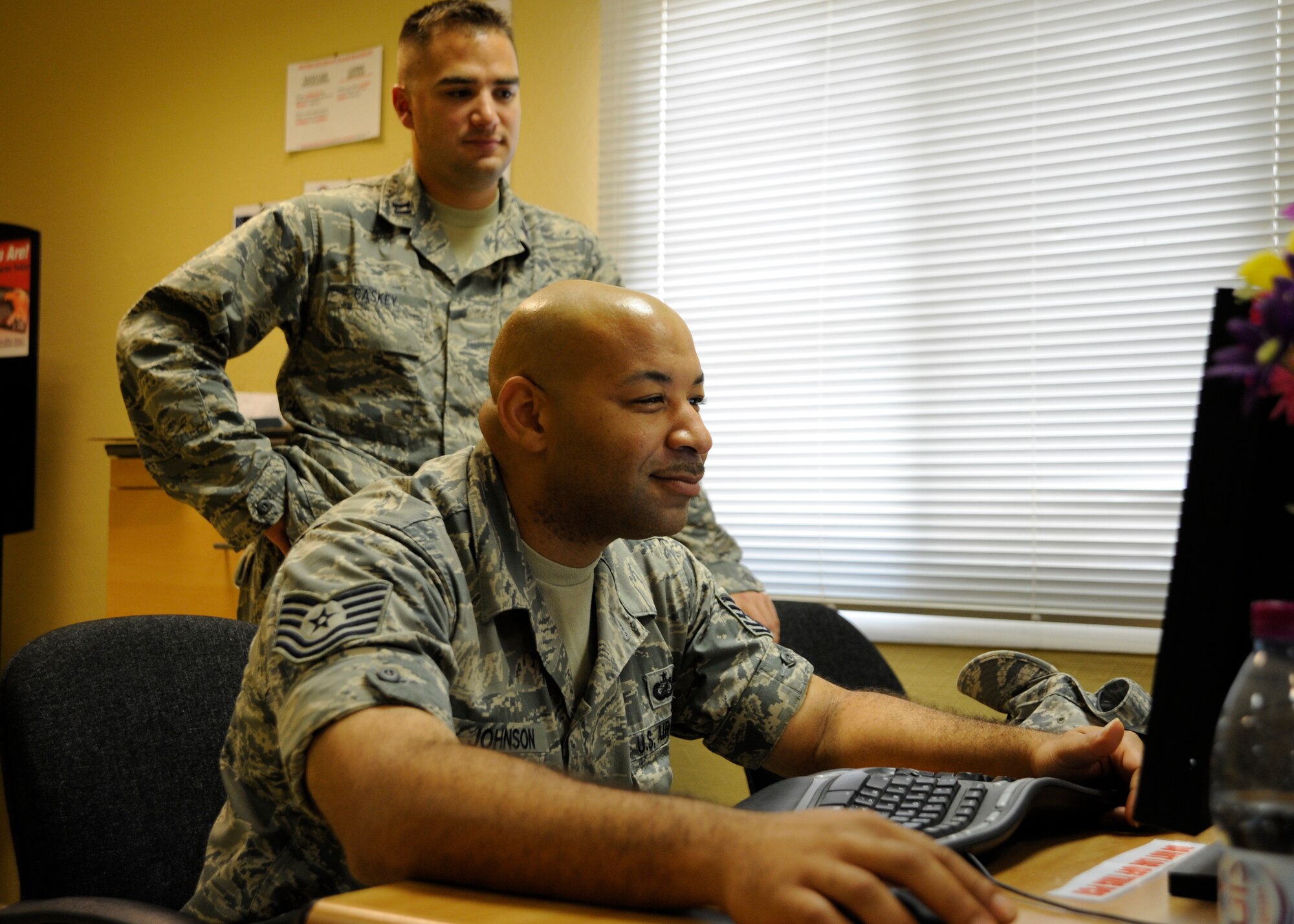 Tech. Sgt. Adrian Johnson assists Capt. Josh Caskey with a financial inquiry at the 379th Air Expeditionary Wing in Southwest Asia, Aug. 26, 2013. Johnson is the 379th Expeditionary Comptroller Squadron customer service NCO in charge deployed from Charleston Air Force Base, S.C., and a Philadelphia, Pa., native. Caskey is the 379th Expeditionary Logistics Readiness Squadron fuels management flight chief deployed from Pope Army Airfield, Fort Bragg, N.C., and hails from O’Neill, Neb. (U.S. Air Force photo/Senior Airman Bahja J. Jones) 