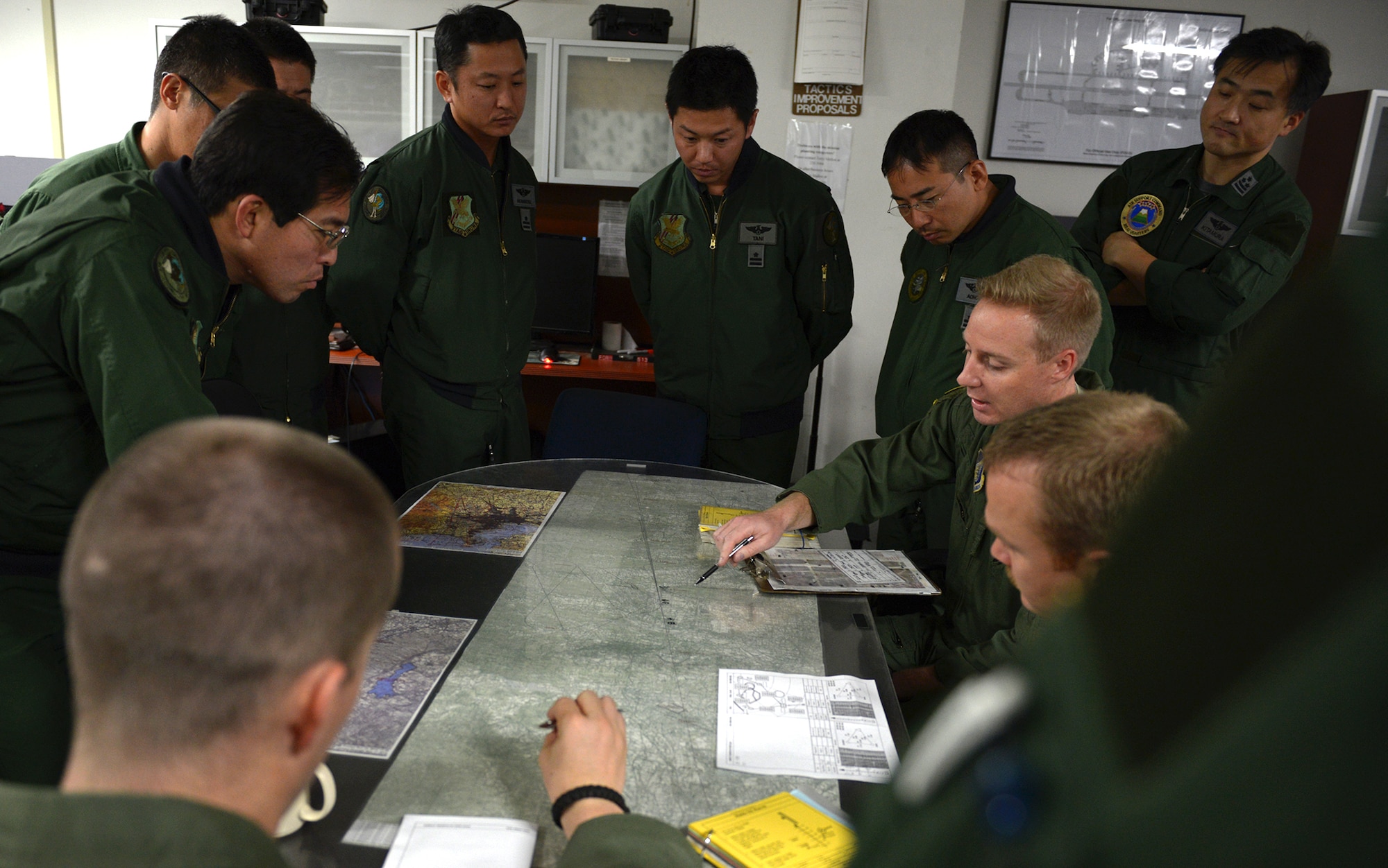 Capt. Ryan Middleton, 36th Airlift Squadron navigator, briefs members of the Japan Air Self-Defense Force about the scheduled flight route at Yokota Air Base, Japan, Nov. 26, 2013. The briefing was part of a daylong bilateral engagement between U.S. and to teach the Japanese members about low-cost, low-altitude airdrops and increase their airlift capabilities. (U.S. Air Force photo by Airman 1st Class David Danford/Released)