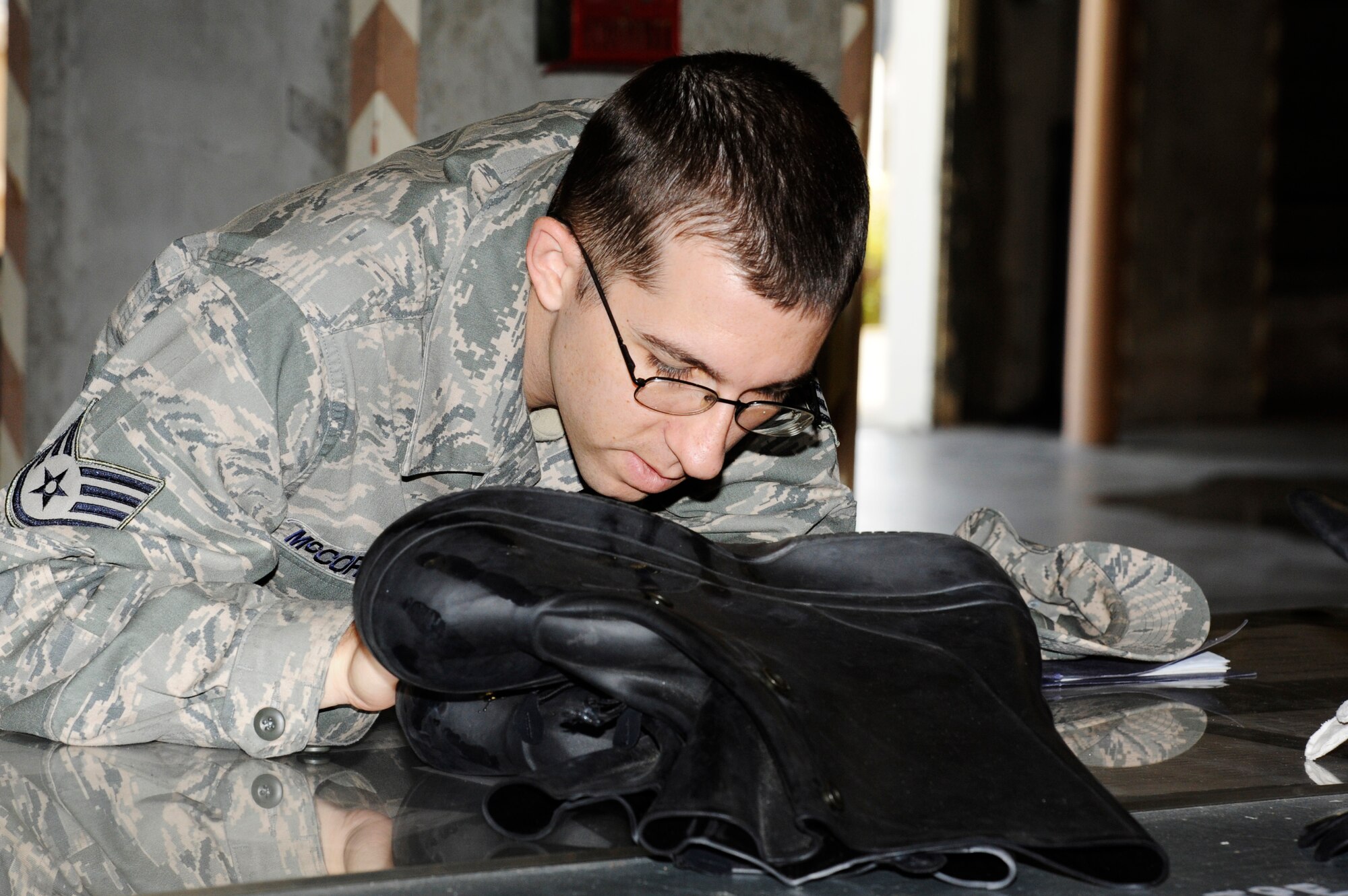 U.S. Air Force Staff Sgt. Kevin McCormack, 18th Aircraft Maintenance Squadron propulsion specialist, verifies the size of his issued mission oriented protective posture gear before turning it into the 18th Logistics Readiness Squadron material management flight on Kadena Air Base, Japan, Nov. 26, 2013. The materiel management flight is in charge of issuing IPE and mobility bags to Airmen for local operational readiness exercises and real-world deployments while maintaining more than 52,000 line items valued at approximately $974 million in their warehouse. (U.S. Air Force photo by Senior Airman Marcus Morris)