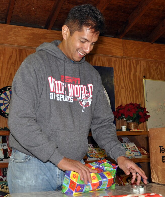 U.S. Air Force Capt. Neil Ocampo wraps a holiday gift to be given to local orphans during a gift wrapping party held at Soto Cano Air Base, Honduras, Nov. 30, 2013.  More than 100 volunteers from Joint Task Force-Bravo participated in the event and wrapped more than 300 gifts to be given to the children.  (U.S. Air Force photo by Capt. Zach Anderson)