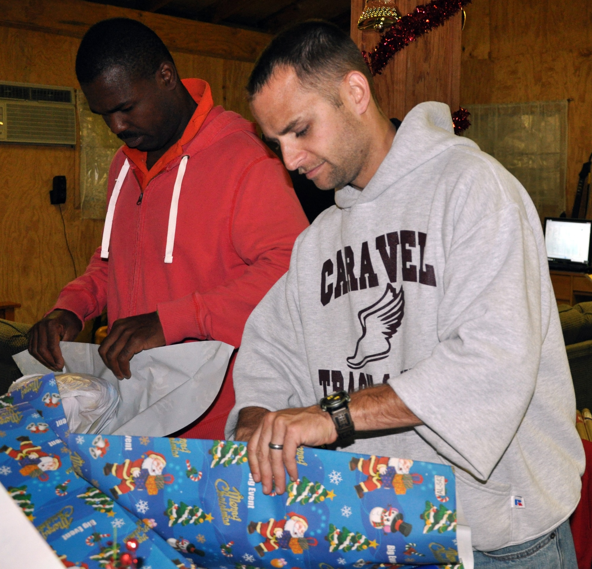 U.S. Army Capt. Jelani Berry and U.S. Air Force Capt. Michael Quashne wrap holiday gifts to be given to local orphans during a gift wrapping party held at Soto Cano Air Base, Honduras, Nov. 30, 2013.  More than 100 volunteers from Joint Task Force-Bravo participated in the event and wrapped more than 300 gifts to be given to the children.  (U.S. Air Force photo by Capt. Zach Anderson)