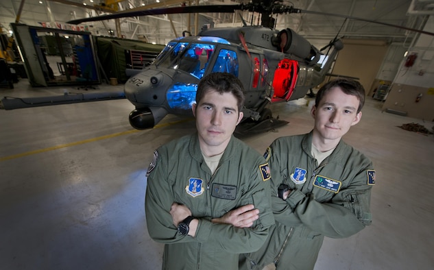 Pararescue Jumper Staff Sgt. Cody Inman, assigned to the 210th Rescue Squadron, Alaska Air  National Guard, left and his brother Special Mission Aviator Staff Sgt. Jacob Inman, assigned to the 212th Rescue Squadron, Alaska Air National Guard, pose for a photograph in front of a HH-60 Pave Hawk helicopter on Joint Base Elmendorf-Richardson, Alaska, Nov. 20, 2013. 