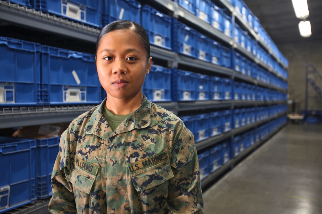 Corporal Diemtrinh Williams, a supply administration and operations specialist with 1st Supply Battalion, Combat Logistics Regiment 15, 1st Marine Logistics Group, stands inside a supply depot aboard Camp Pendleton, Calif., Nov. 21. Williams immigrated to America when she was seven years old and settled in Salina, Kan., which she now considers home. Even though the 21-year-old Marine has spent more than half her life in the states, she still remembers her roots and uses it to motivate herself and the Marines around her.