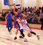 Air Force 2d Lt Mike Lyons (USAFA, CO) gets by his opponent for the score during the 2013 SHAPE International Basketball Tournament held at SHAPE (Mons), Belgium 24-30 November.  USA defeats Kazakhstan 104-55.