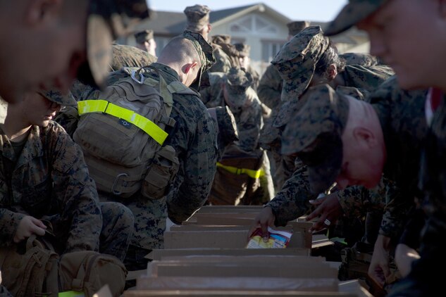 Marines from Headquarters Battalion and Marine Corps Air Station Kaneohe Bay, empty nonperishable items from their packs into boxes for donation to the Armed Services YMCA Thanksgiving food baskets, Nov. 22, 2013. (U.S. Marine Corps photo by Lance Cpl. Janelle Y. Villa) 