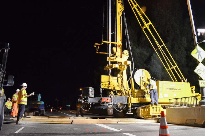 U.S. Army Corps of Engineers construction crews use wooden planks to help a jet-grout drill cross a closed portion of Watt Avenue bridge in Sacramento, Calif., Aug. 15, 2013. Corps representatives, the project contractor and the California Highway Patrol closed three lanes of traffic during non-commute hours in order to drill through the bridge to access the levee.