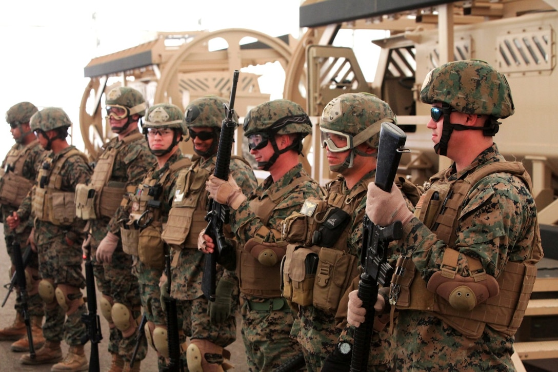 Marines with 1st Air Naval Gunfire Liaison Company receive rubber M-16s before entering the mine resistant, ambush protected vehicle rollover simulator aboard Camp Pendleton, Calif., Nov. 20, 2013.