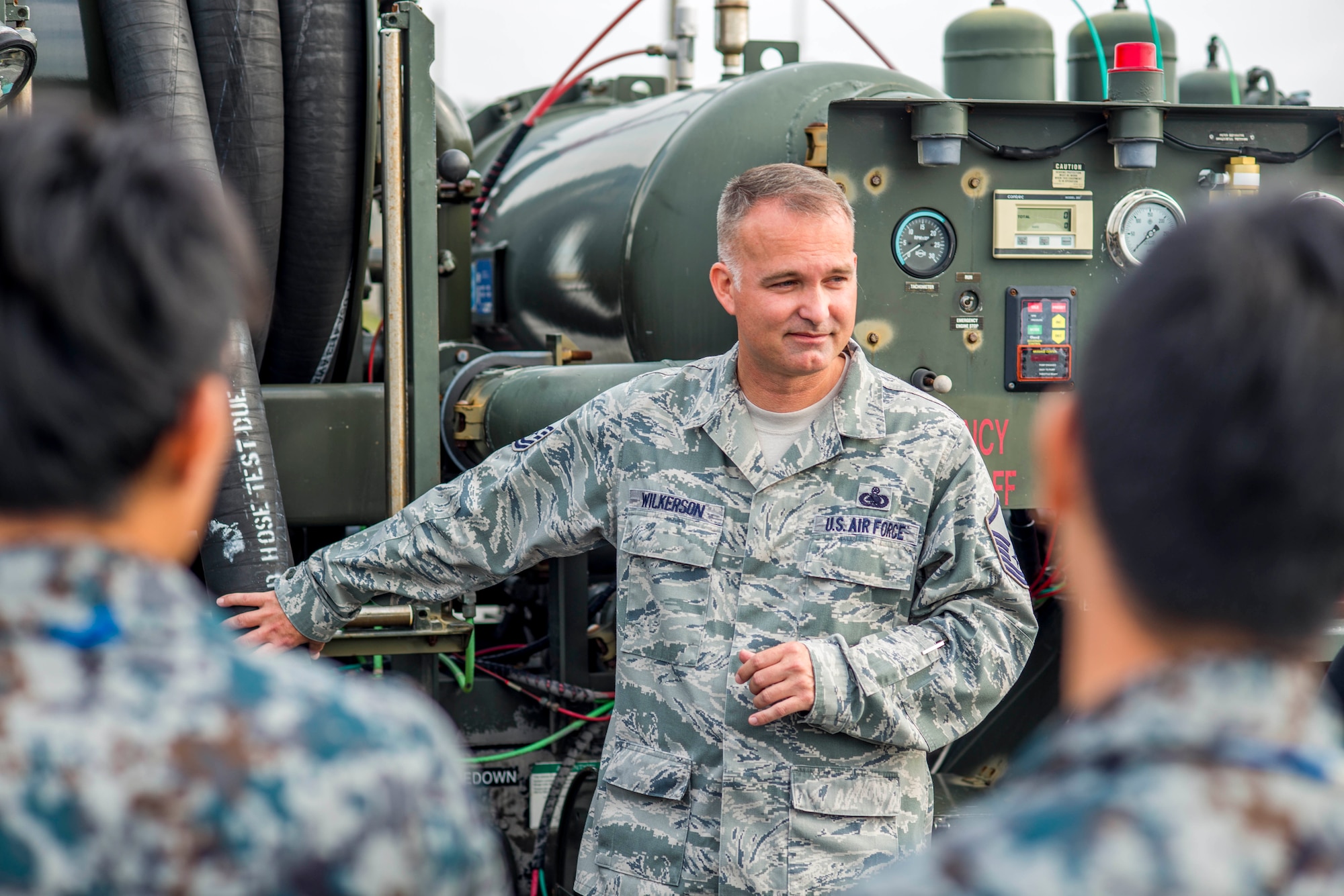 U.S. Air Force Master Sgt. Dustin Wilkerson, 18th Logistics Readiness Squadron fuels management flight fuels craftsman, teaches members of the Japanese Air Self Defense Force about the different equipment used for his career field on Kadena Air Base, Japan, Nov. 21, 2013. The fuels management flight issues over 55 million gallons of fuel a year valued at more than $240 million. (U.S. Air Force photo by Airman 1st Class Tyler Prince) 