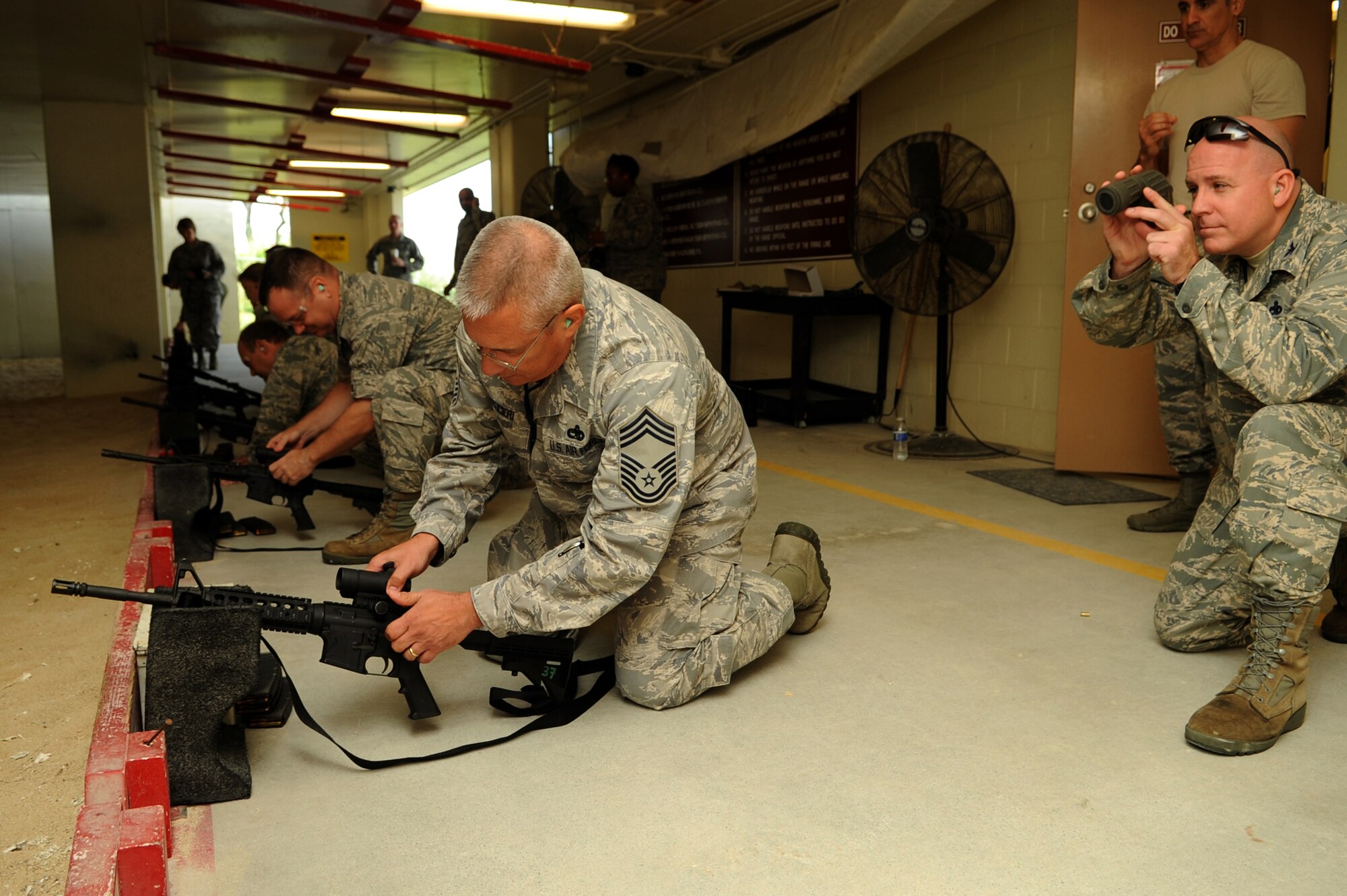U.S. Air Force Chief Master Sgt. Daniel Maucieri, 18th Maintenance Group chief, removes a scope off of an M-4 rifle while his partner Col. Jeffrey King, 18th Maintenance Group commander, assists him during a "turkey shoot" on Kadena Air Base, Japan, Nov. 26, 2013. Rather than using a sighting scope on the M-4 rifle, each team had to rely on their teammate to help them accurately hit a target by using a handheld scope. (U.S. Air Force photo by Staff Sgt. Amber E. N. Jacobs)