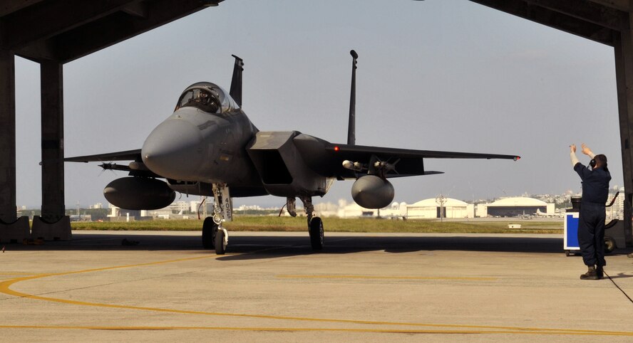 U.S. Air Force Senior Airman Thomas Debruyne, 18th Aircraft Maintenance Unit F-15 Eagle crew chief, marshalls an F-15 heading to Guam for Forager Fury II at Kadena Air Base, Japan, Nov. 26, 2013. The 44th Fighter Squadron deployed 14 of their F-15 Eagles to Andersen Air Base, Guam for exercise Forager Fury II. (U.S. Air Force photo by Naoto Anazawa)