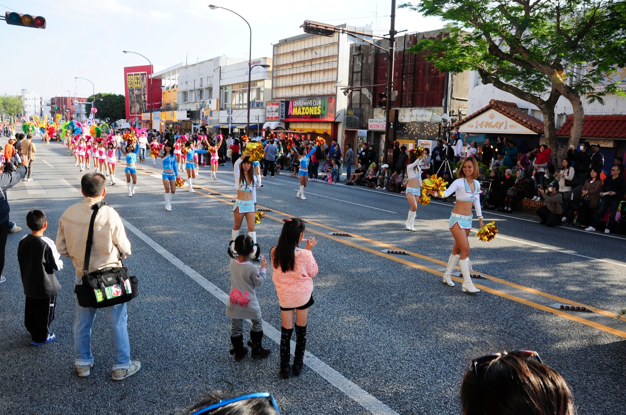 Parade participants entertain spectators at Kadena's Gate 2 while they march during the International Carnival in Okinawa, Japan, Nov. 30, 2013. This is the 22nd carnival which promotes international friendships across diverse cultures through a variety of music, sports and stage events. (U.S. Air Force photo by Staff Sgt. Darnell T. Cannady)