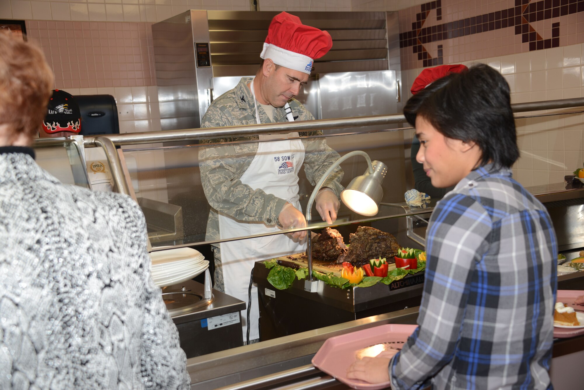 Col. Vincent Becklund, 58th Special Operations Wing commander, slices roast beef while serving a Thanksgiving meal at the Kirtland Dining Facility.  Senior leaders were at the facility Thanksgiving Day to serve dinner to Airmen and retirees. (Photo by Dennis Carlson)